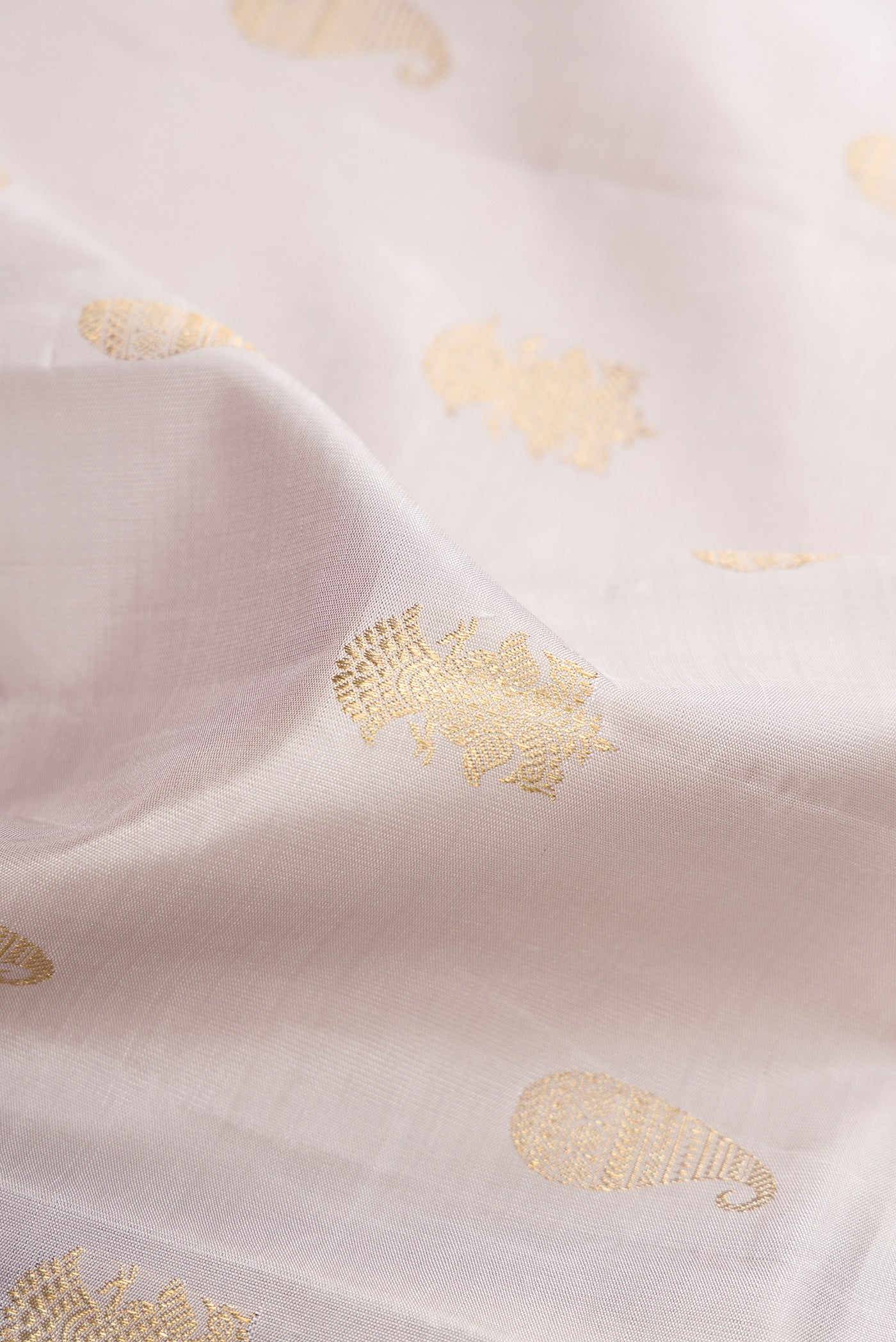 Close up of Pure Silk Pure Zari Grey Kanchipuram Saree with Zari Butta on the body and Thin Zari Line.  displaying folds