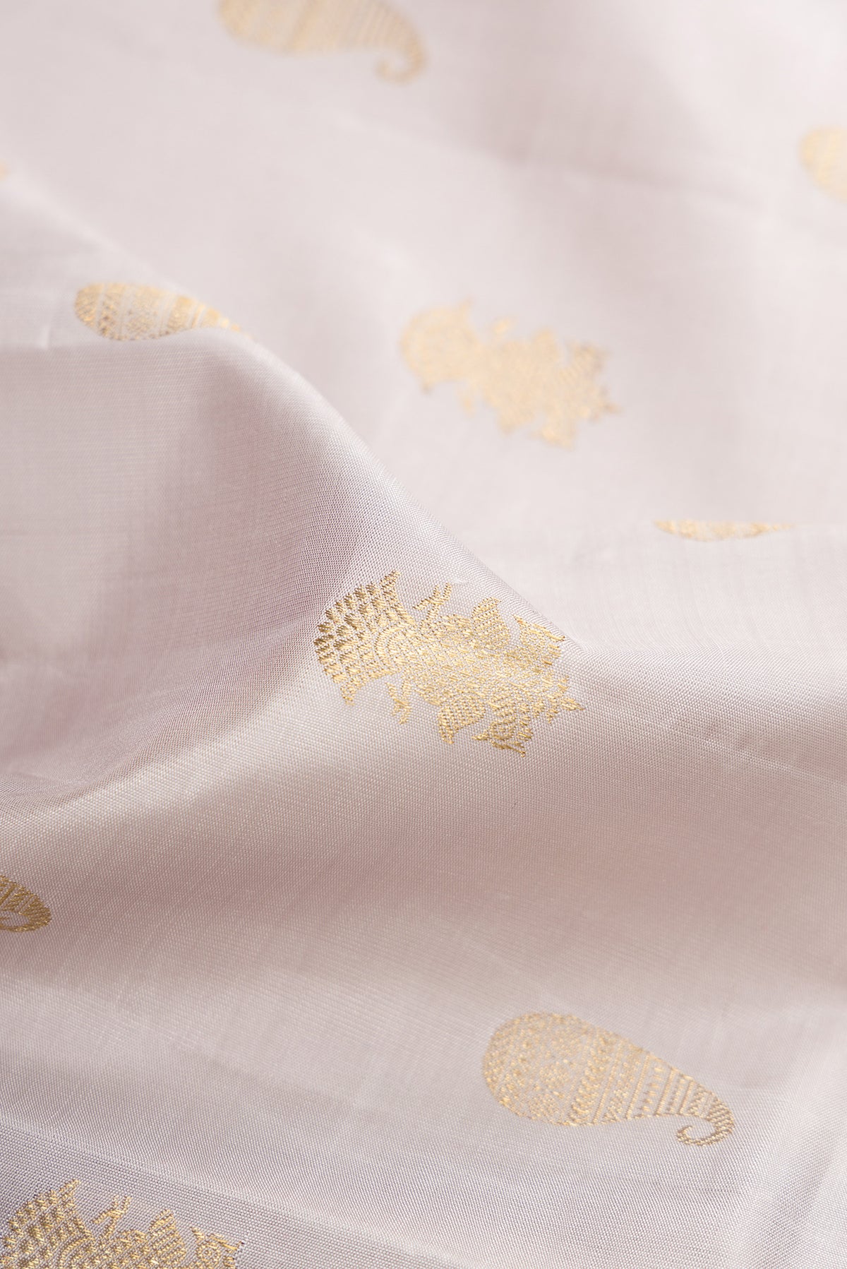 Close up of Pure Silk Pure Zari Grey Kanchipuram Saree with Zari Butta on the body and Thin Zari Line.  displaying folds