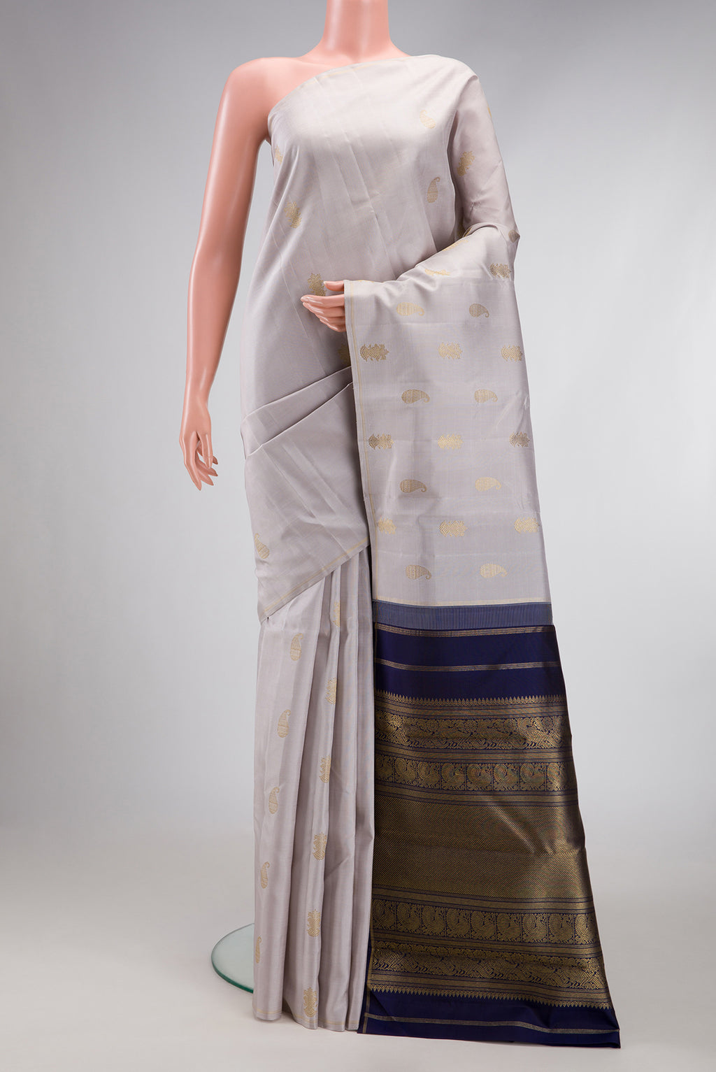 Pure Silk Pure Zari Grey Kanchipuram Saree with Zari Butta on the body and Thin Zari Line.  displayed on a mannequin