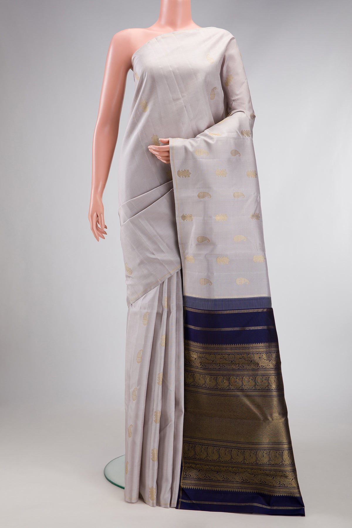 Pure Silk Pure Zari Grey Kanchipuram Saree with Zari Butta on the body and Thin Zari Line.  displayed on a mannequin