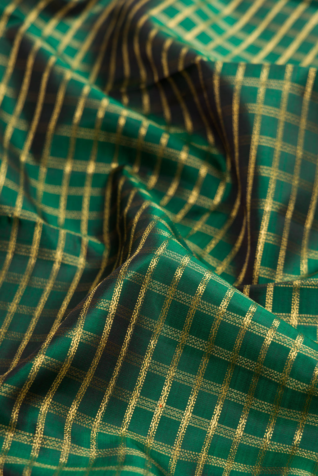 Close up of Pure Silk Pure Zari Bottle Green Dual Tone Kanjivaram Saree with Zari Brocade on the body and Zari Border.  displaying folds