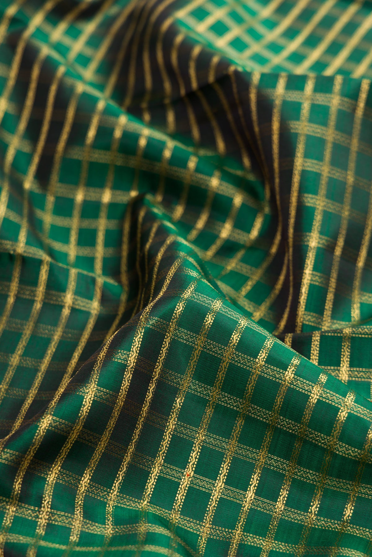 Close up of Pure Silk Pure Zari Bottle Green Dual Tone Kanjivaram Saree with Zari Brocade on the body and Zari Border.  displaying folds