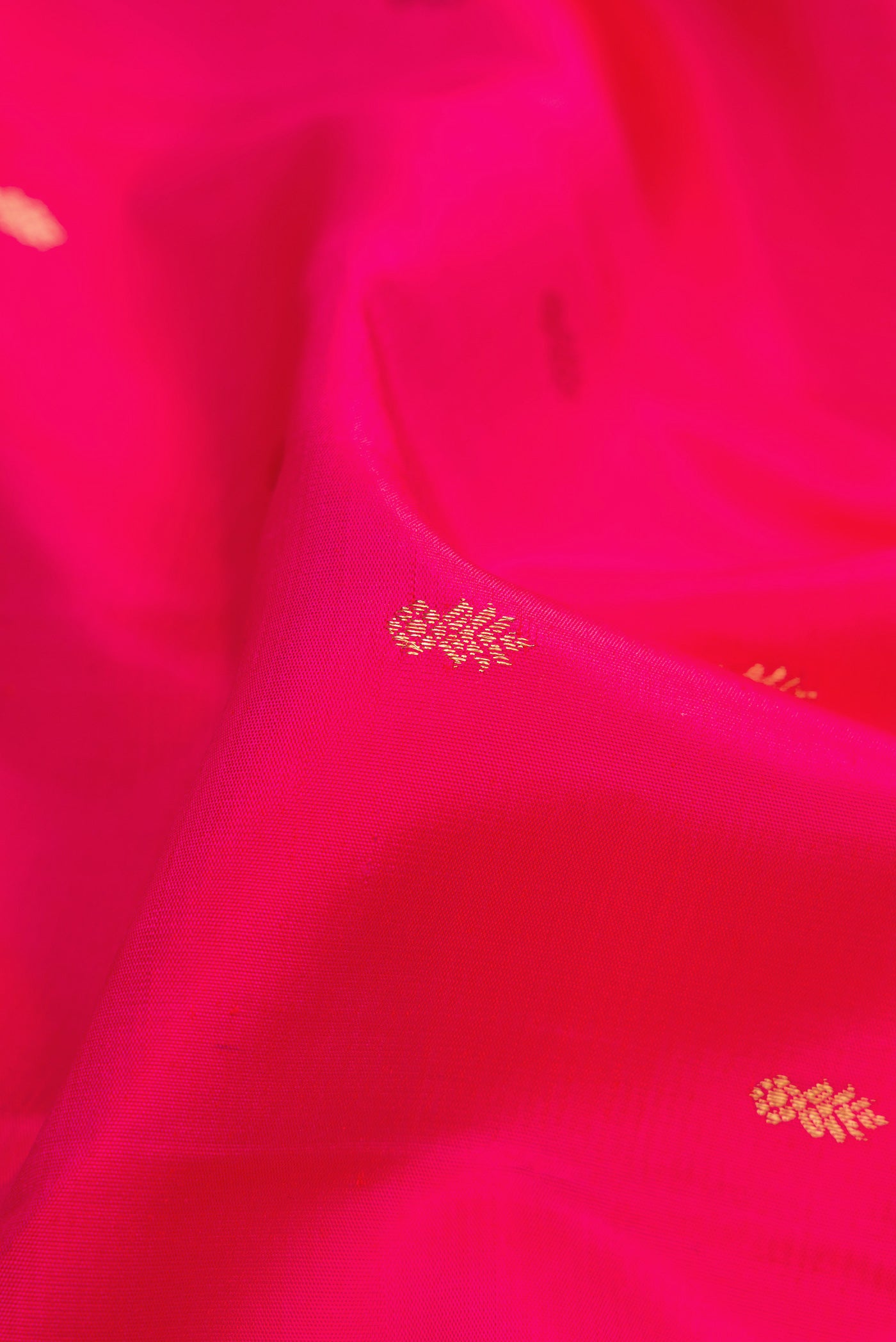 Close up of Pure Silk Pure Zari Pink Dual Tone Kanjivaram Saree with Zari Butta on the body and Zari Border.  displaying folds