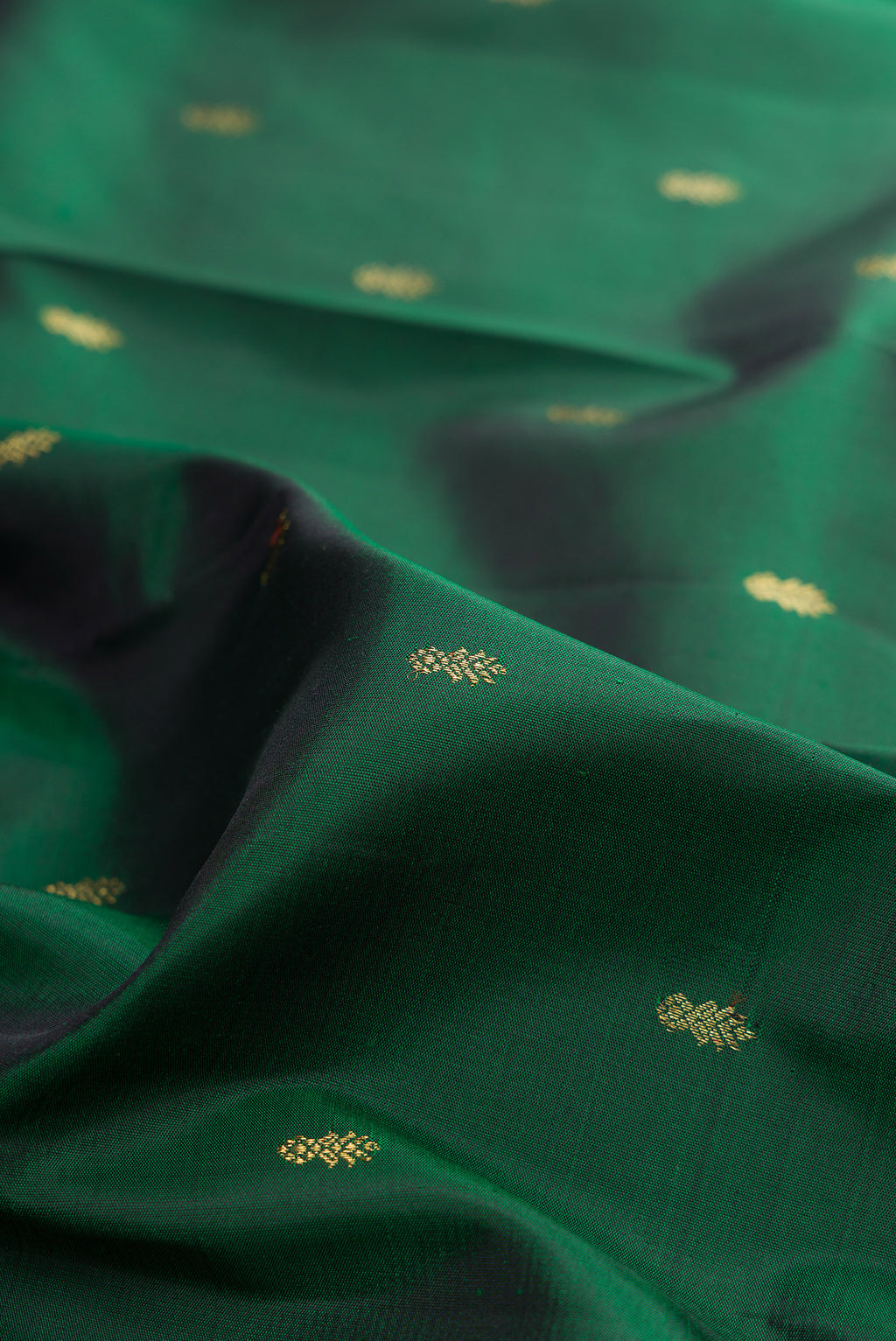 Close up of Pure Silk Pure Zari Bottle Green Kanjivaram Saree with Zari Butta on the body and Zari Border.  displaying folds