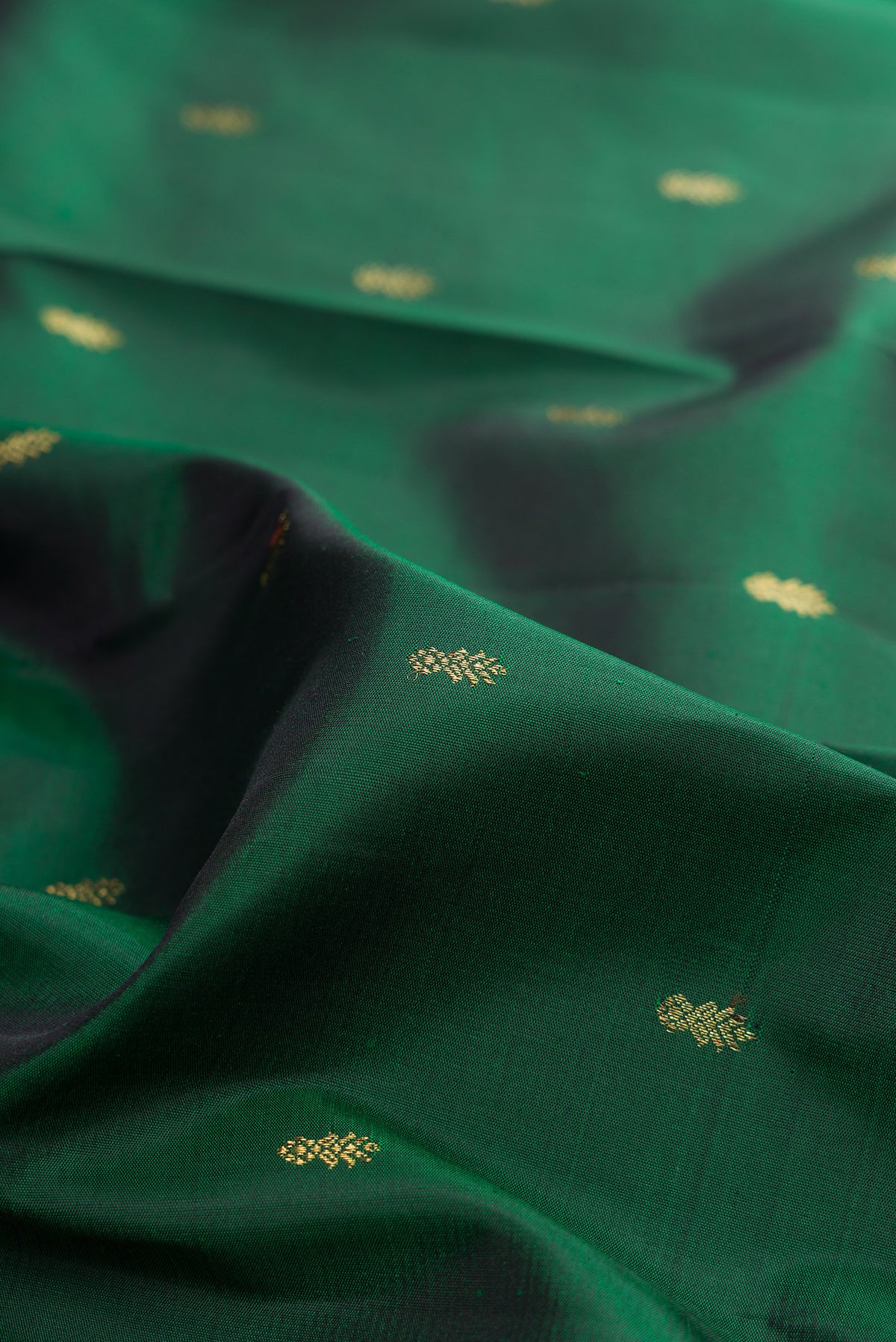 Close up of Pure Silk Pure Zari Bottle Green Kanjivaram Saree with Zari Butta on the body and Zari Border.  displaying folds