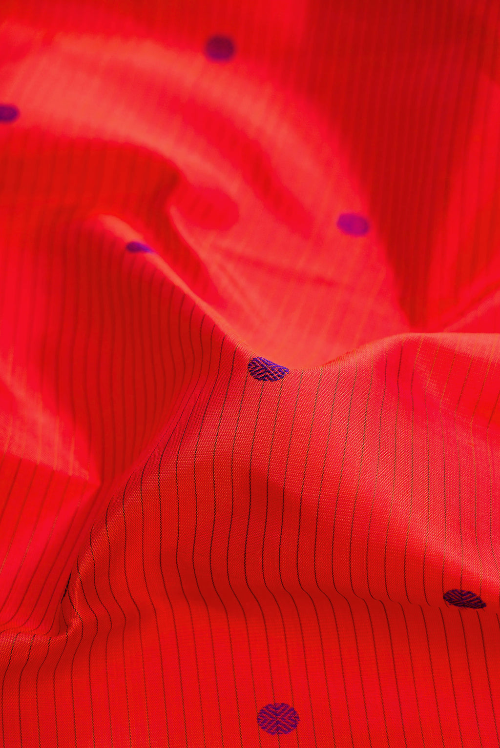 Close up of Pure Silk Pure Zari Orange Dual Tone Kanjivaram Saree with Thread Butta on the body and Zari Border.  displaying folds