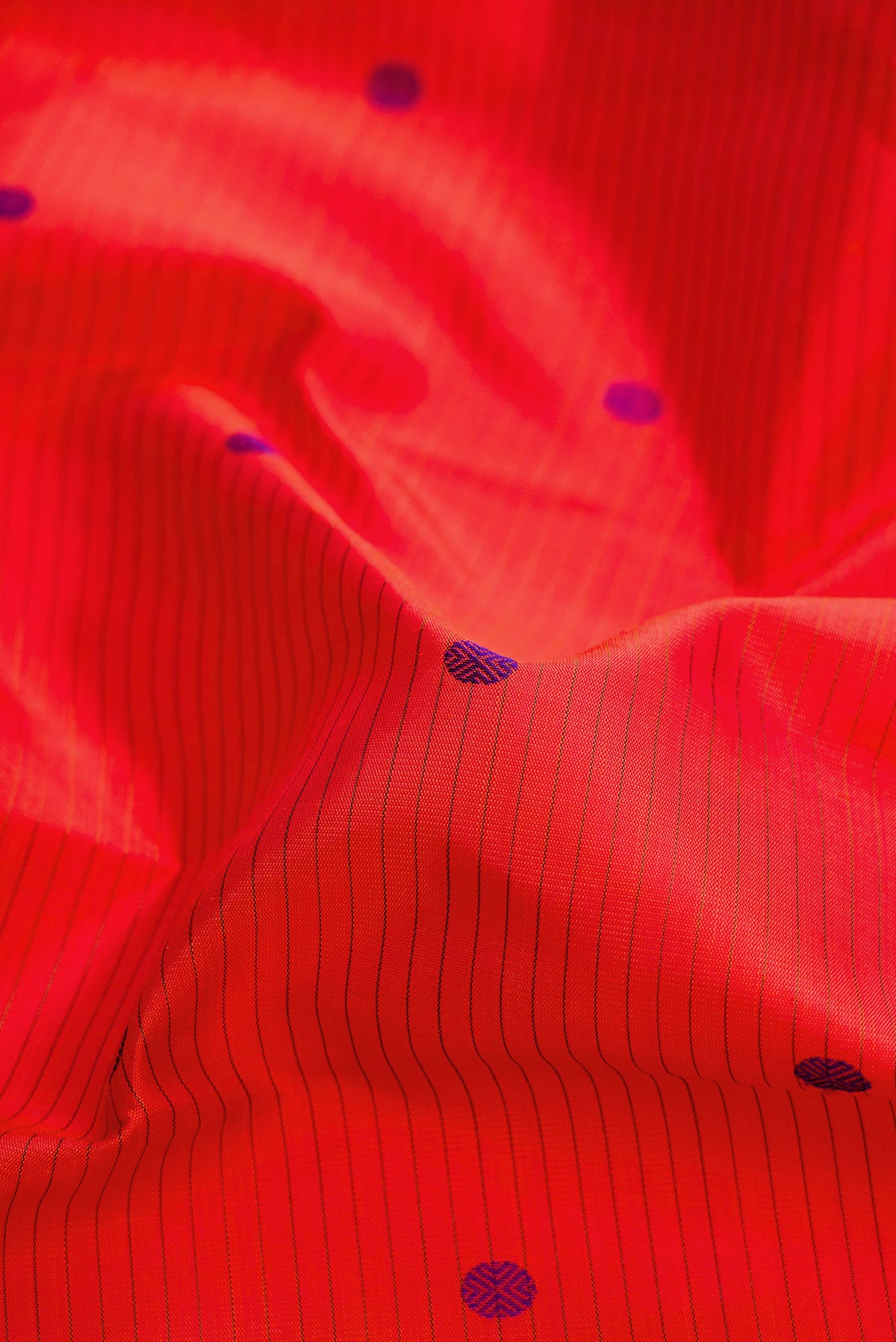 Close up of Pure Silk Pure Zari Orange Dual Tone Kanjivaram Saree with Thread Butta on the body and Zari Border.  displaying folds