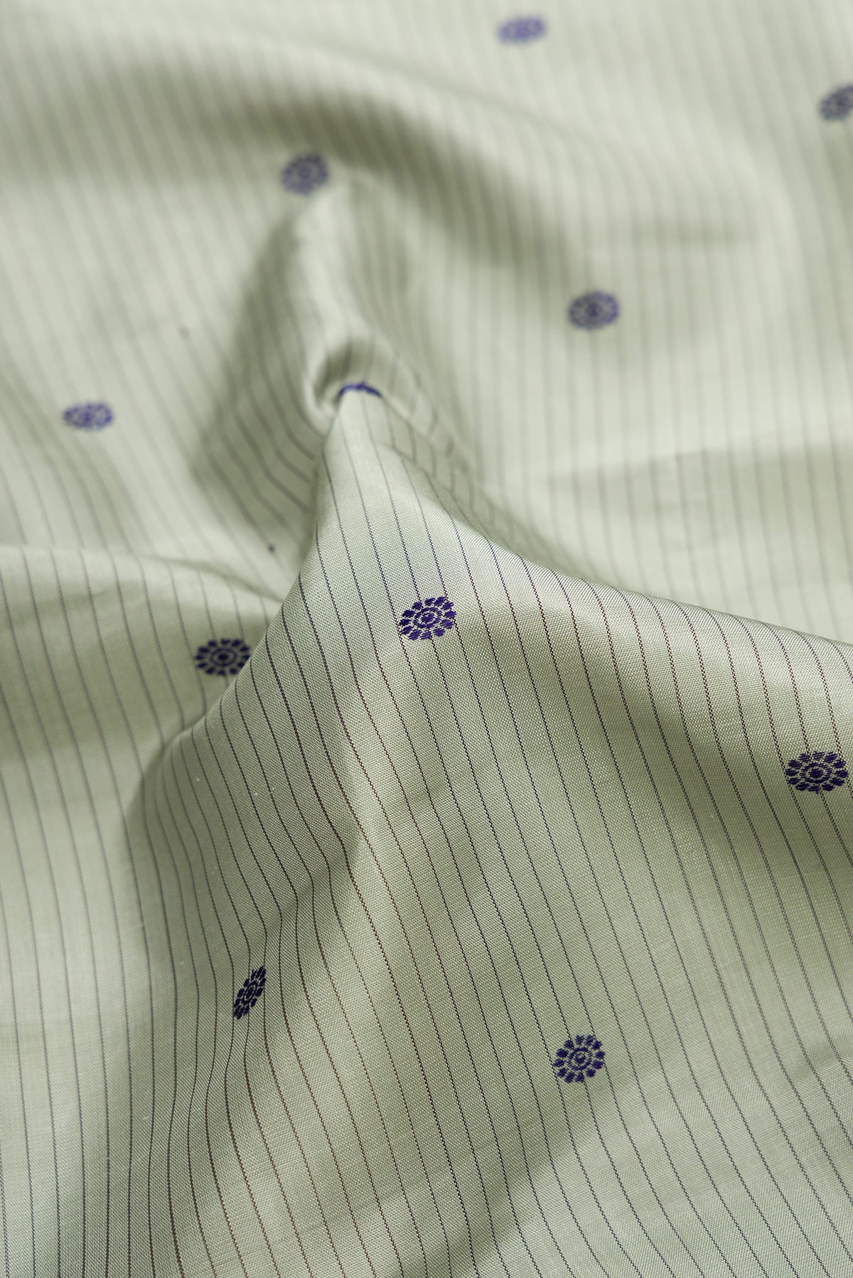 Close up of Pure Silk Pure Zari Grey Dual Tone Kanjivaram Saree with Stripes on the body and Zari Border.  displaying folds