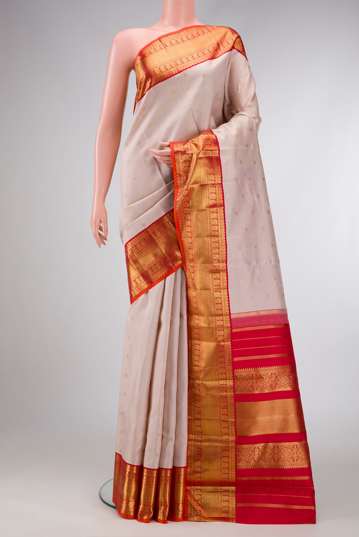 Pure Silk Pure Zari Rose Gold Dual Tone Kanjivaram Saree with Zari Butta on the body and Zari Border.  displayed on a mannequin