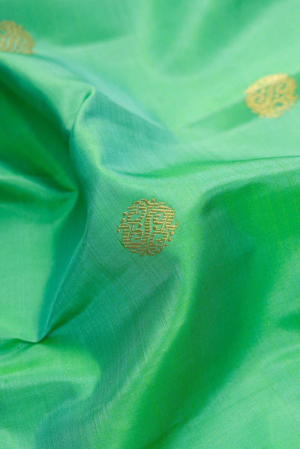 Close up of Pure Silk Pure Zari Sea Green Dual Tone Kanjivaram Saree with Zari Butta on the body and Fancy Border.  displaying folds
