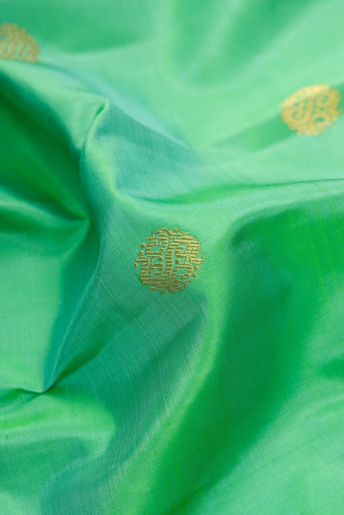 Close up of Pure Silk Pure Zari Sea Green Dual Tone Kanjivaram Saree with Zari Butta on the body and Fancy Border.  displaying folds