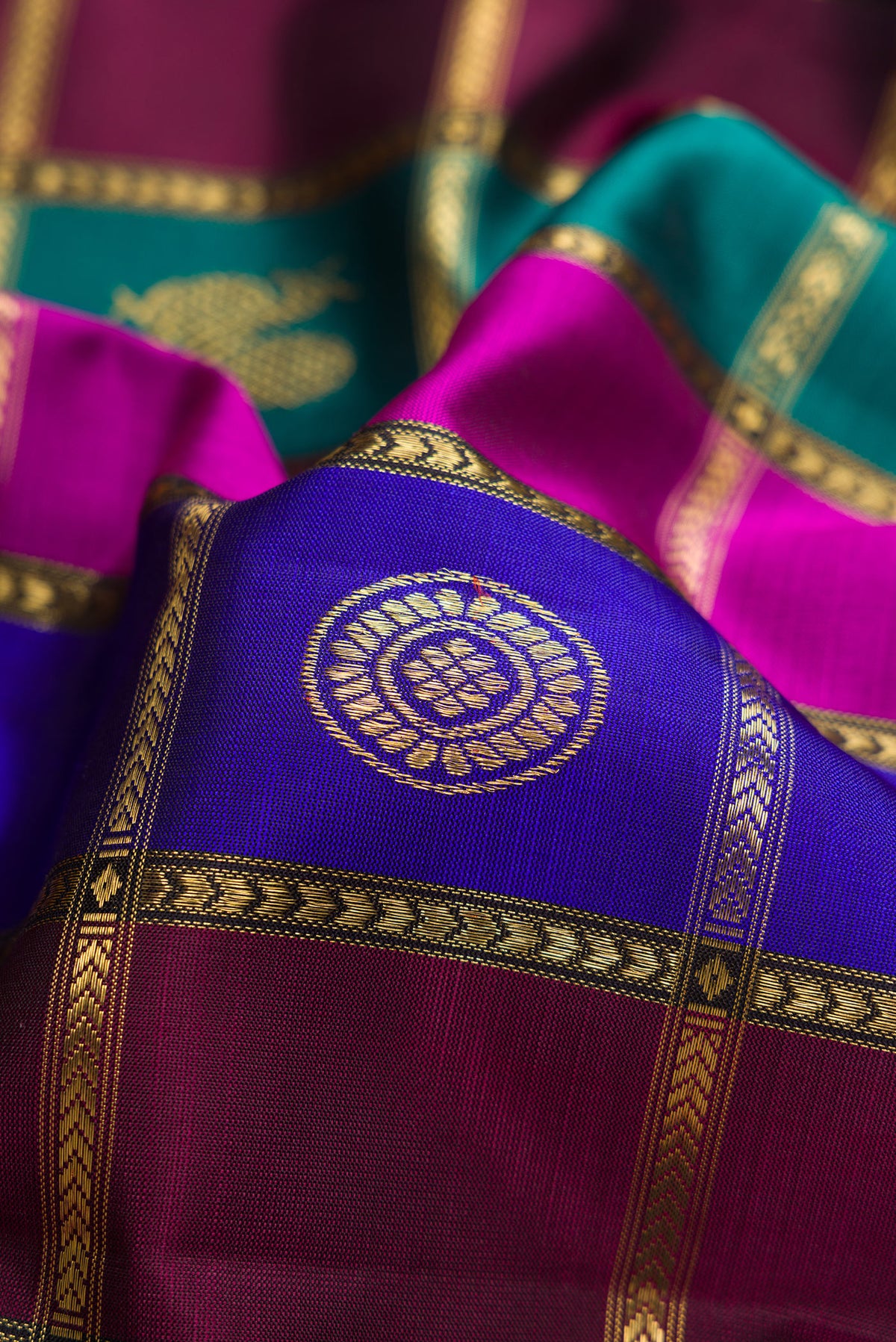 Close up of Pure Silk Pure Zari Green, Royal Blue and Maroon Color Kanjivaram Saree with Checked design on the body and Zari Border.  displaying folds
