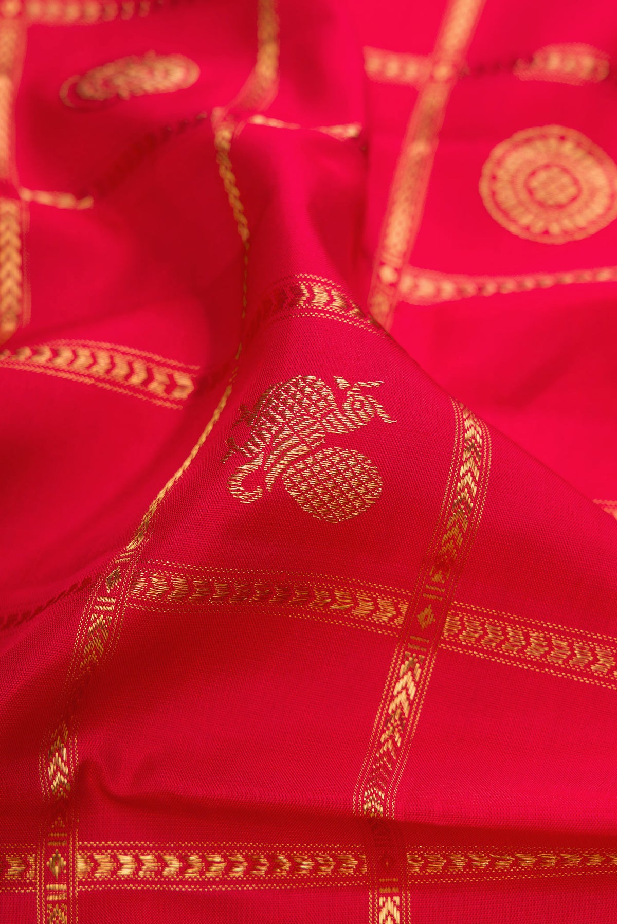 Close up of Pure Silk Pure Zari Red Kanjivaram Saree with Checked design on the body and Fancy Border.  displaying folds
