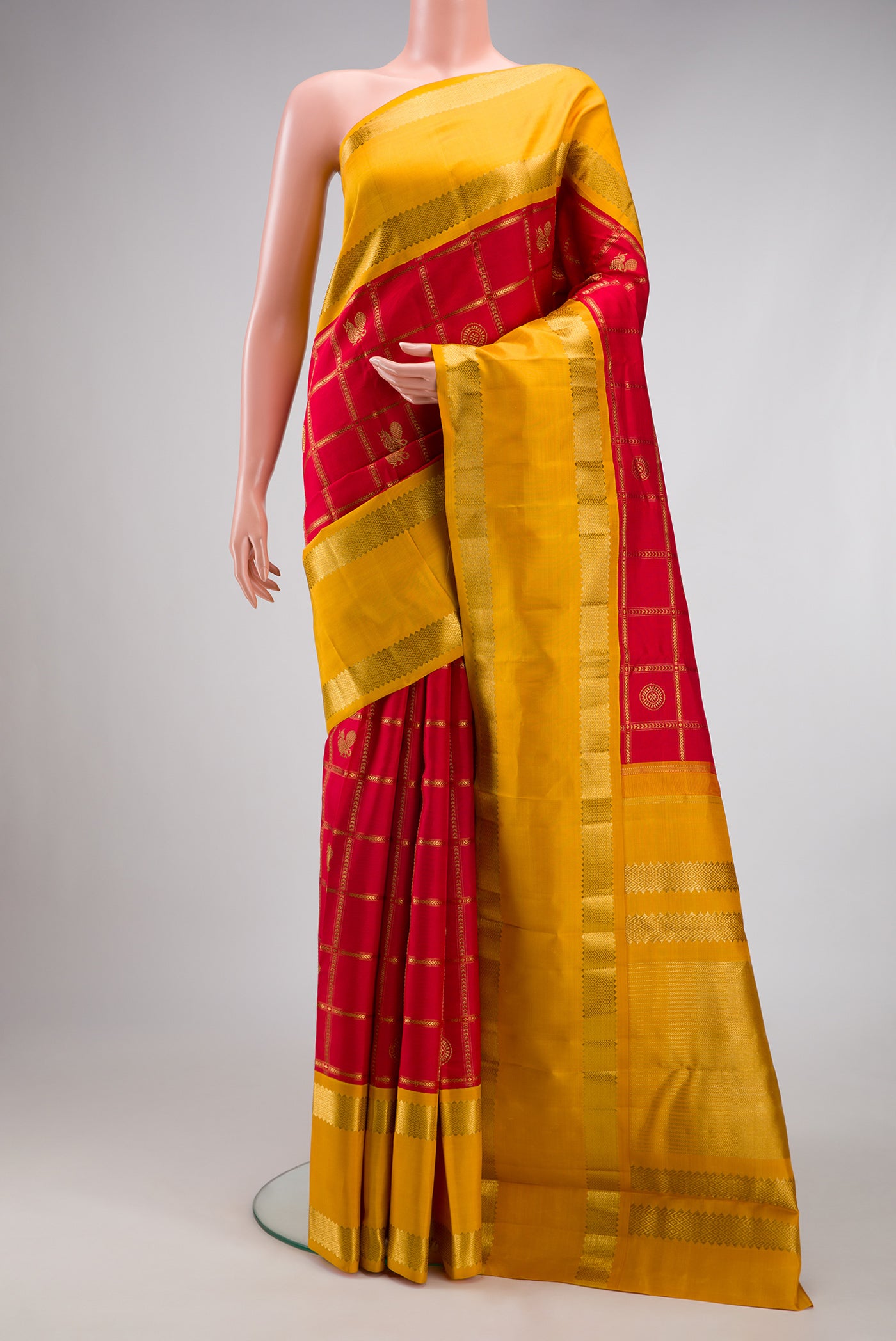 Pure Silk Pure Zari Red Kanjivaram Saree with Checked design on the body and Fancy Border.  displayed on a mannequin