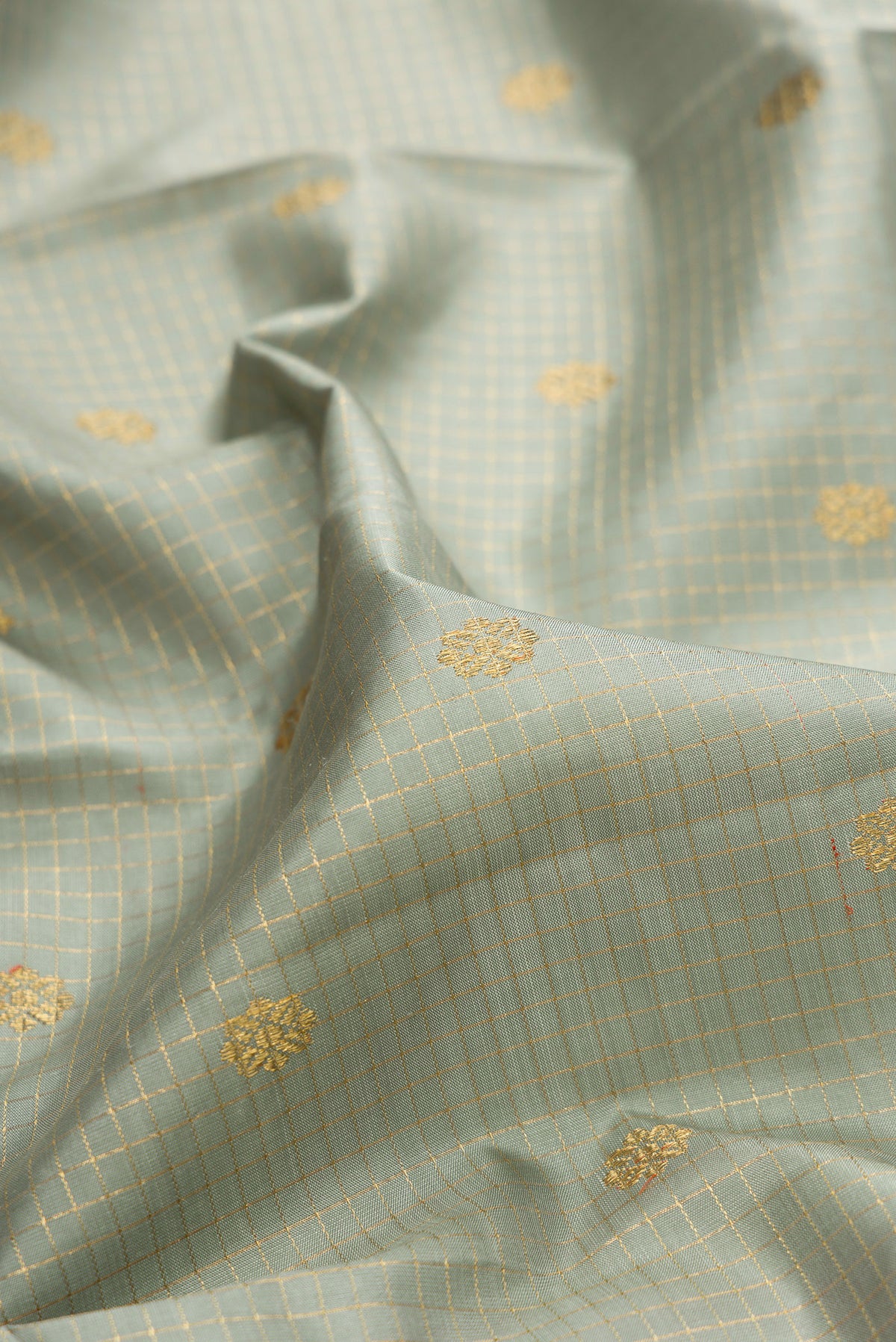 Close up of Pure Silk Pure Zari Grey Kanjivaram Saree with Checked design on the body and Zari Border.  displaying folds