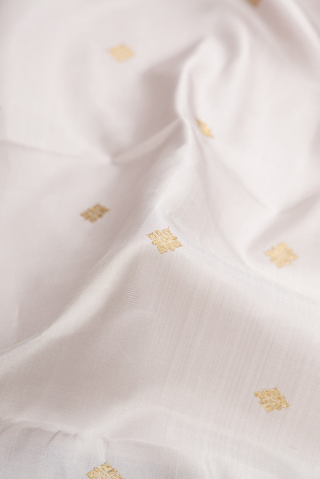Close up of Pure Silk Pure Zari Grey Kanjivaram Saree with Zari Butta on the body and Zari Border.  displaying folds
