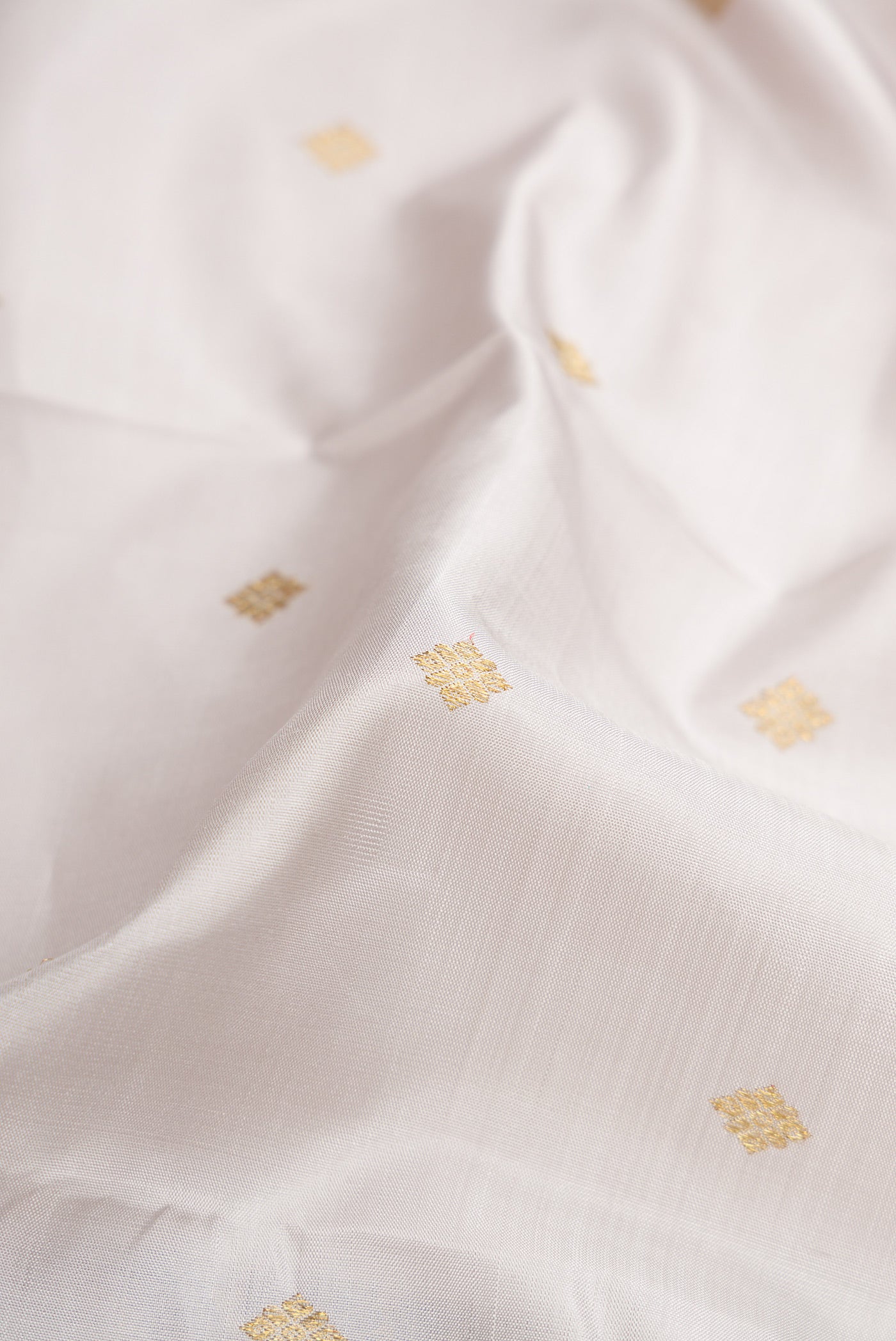 Close up of Pure Silk Pure Zari Grey Kanjivaram Saree with Zari Butta on the body and Zari Border.  displaying folds