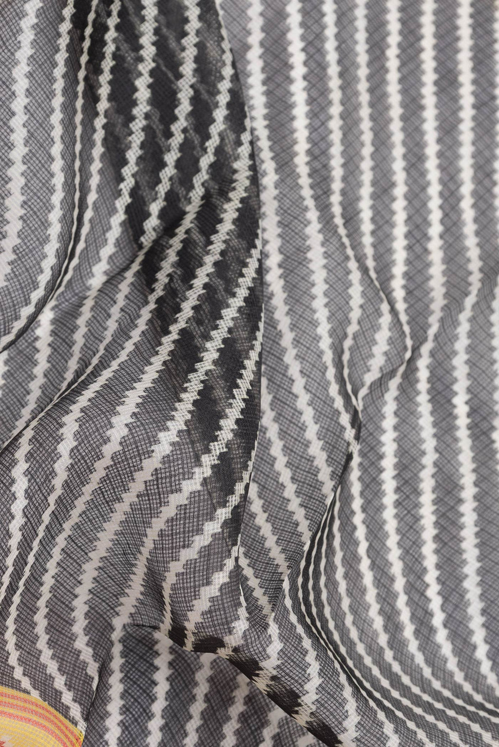 Close up of Black Dual Tone Kota Silk Saree with Printed design on the body and Fancy Border.  displaying folds