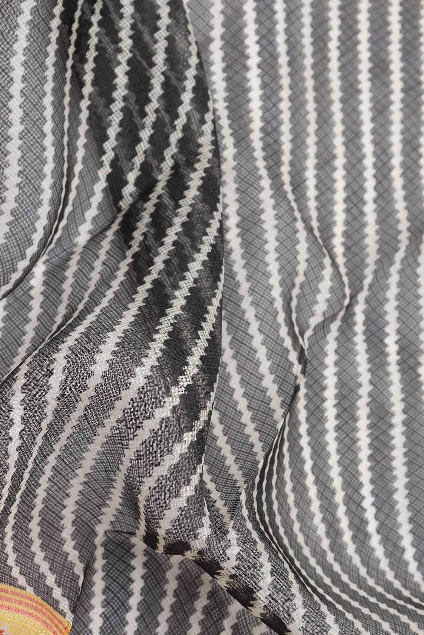 Close up of Black Dual Tone Kota Silk Saree with Printed design on the body and Fancy Border.  displaying folds