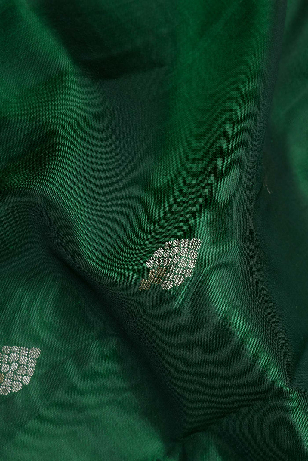 Close up of Pure Silk Bottle Green Dual Tone Soft Saree with Zari Butta on the body and Zari Border.  displaying folds