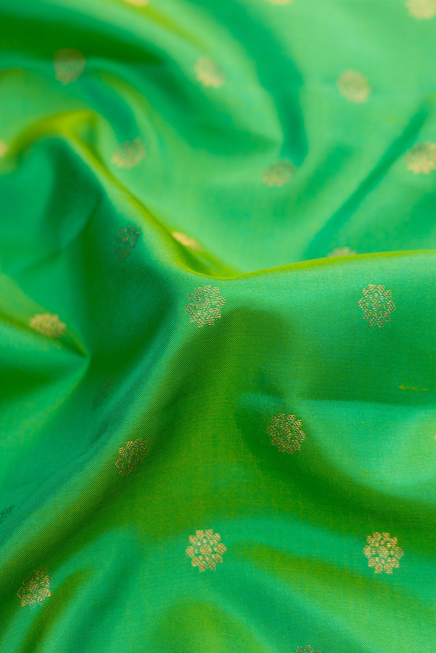 Close up of Green Dual Tone Gadwal Silk Saree with Zari Butta on the body and Zari Border.  displaying folds