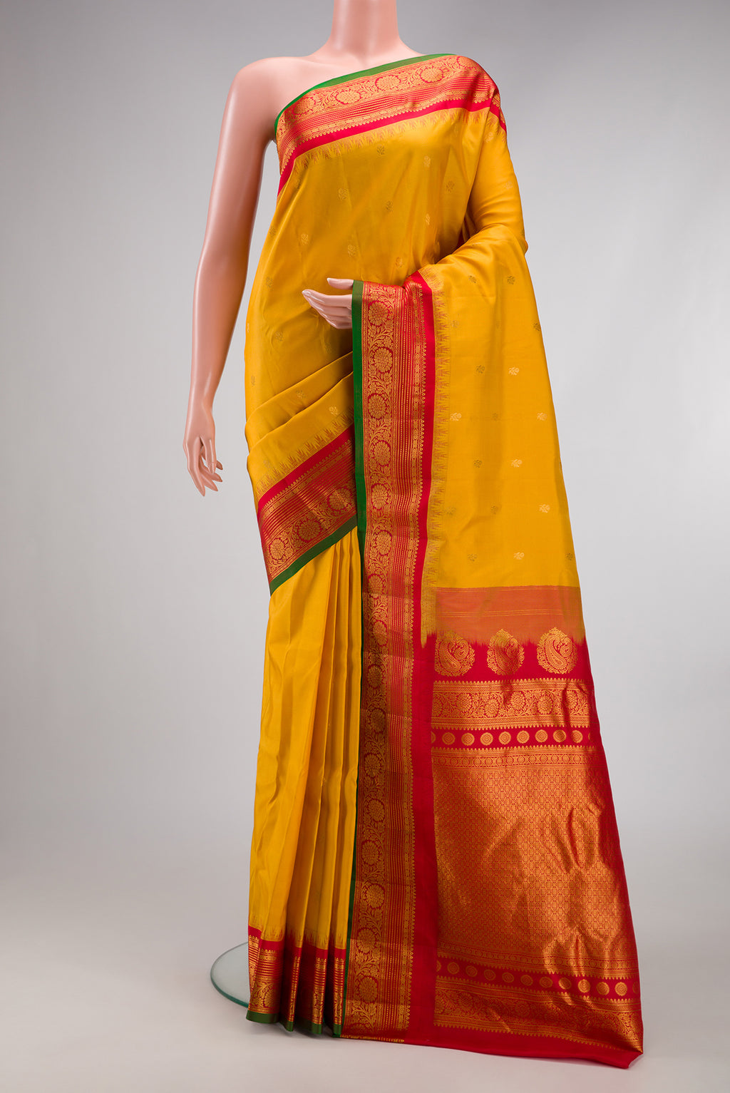 Mustard Gadwal Silk Saree with Zari Butta on the body and Zari Border.  displayed on a mannequin