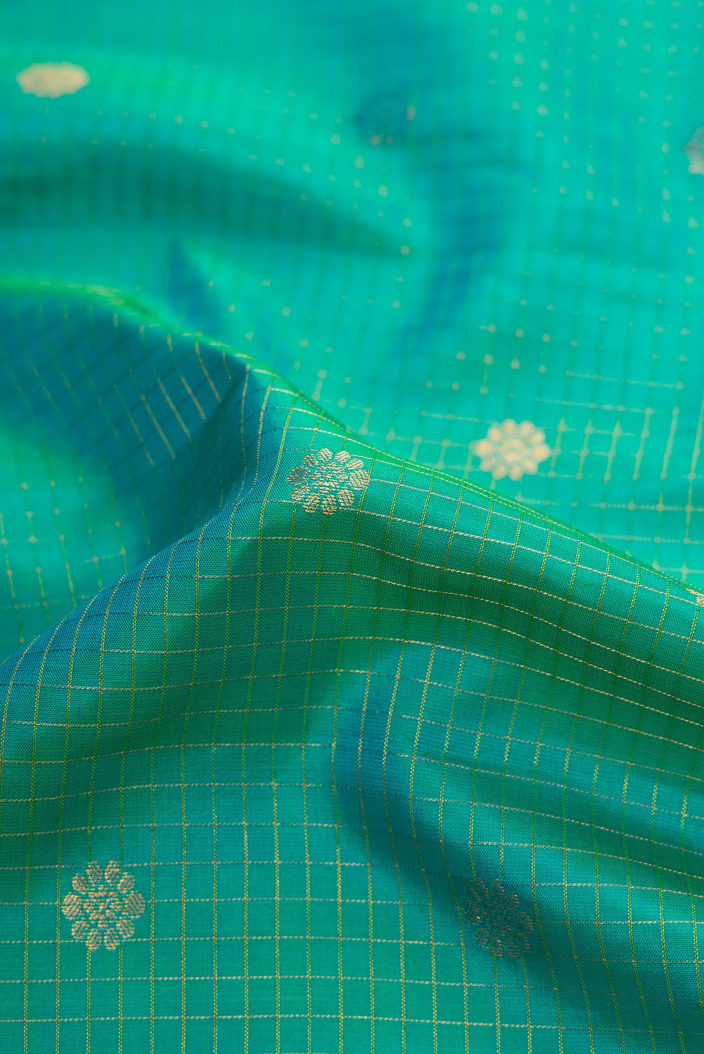 Close up of Green Dual Tone Gadwal Silk Saree with Checked design on the body and Zari Border.  displaying folds