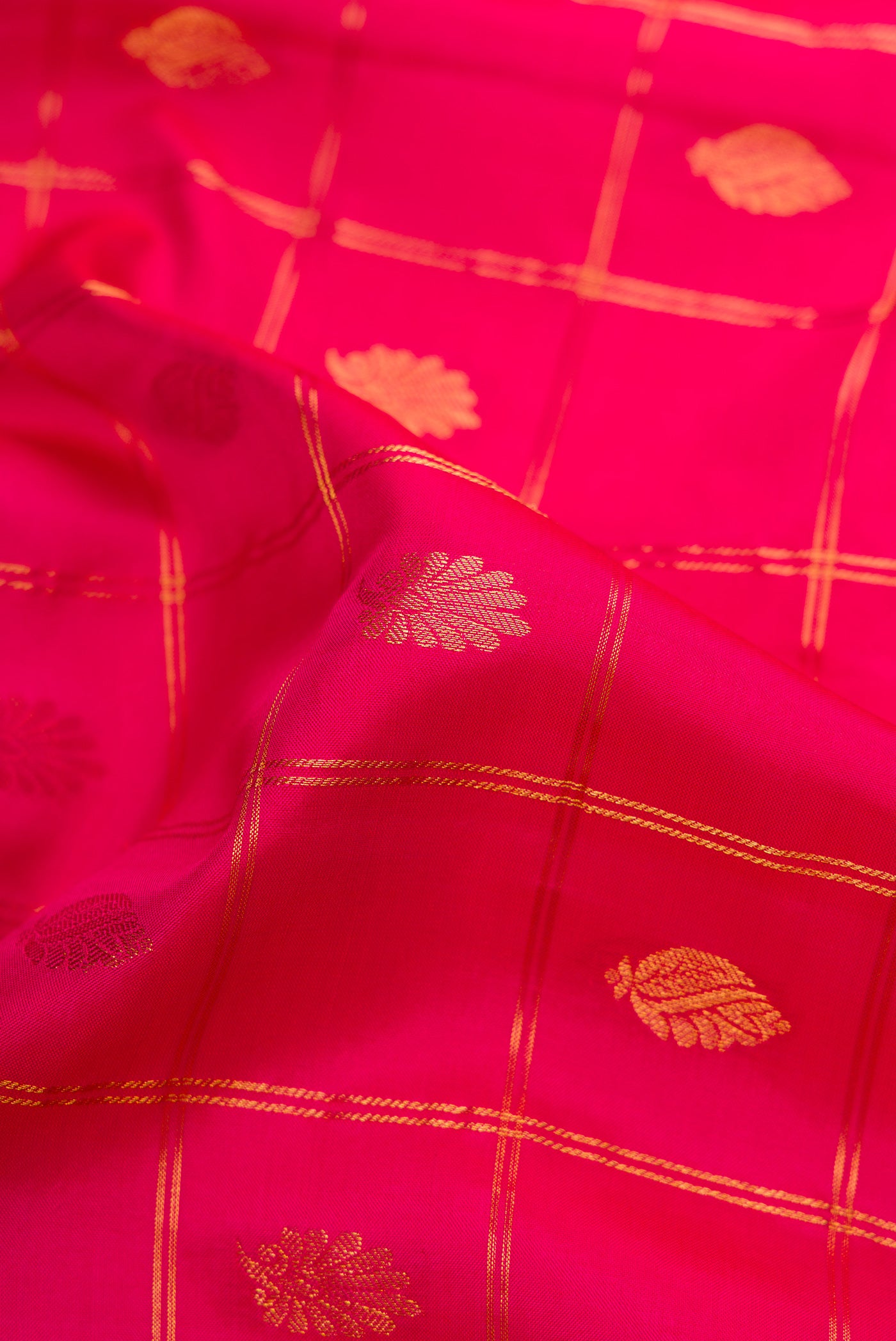 Close up of Dark Pink Dual Tone Gadwal Silk Saree with Checked design on the body and Zari Border.  displaying folds