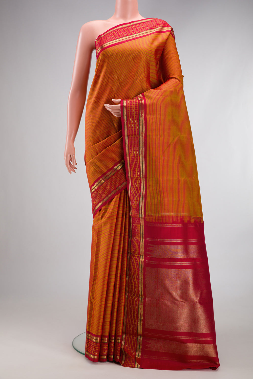 Pure Silk Pure Zari Mustard Kanjivaram Saree with Stripes on the body and Fancy Border.  displayed on a mannequin