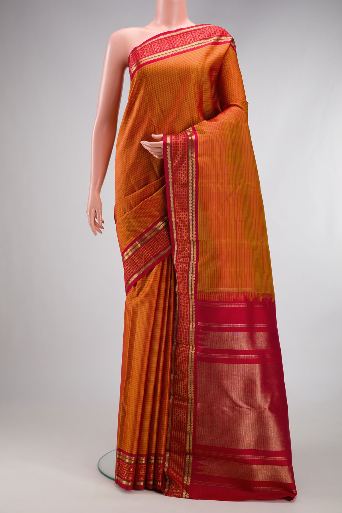 Pure Silk Pure Zari Mustard Kanjivaram Saree with Stripes on the body and Fancy Border.  displayed on a mannequin
