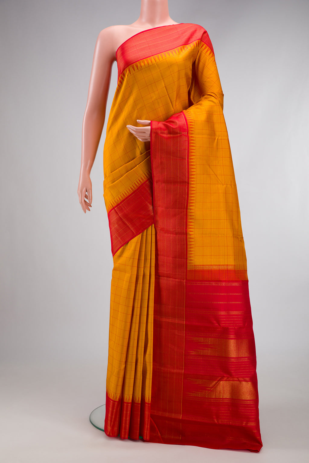Mustard Kanjivaram Silk Saree with Checked design on the body and Zari Border.  displayed on a mannequin