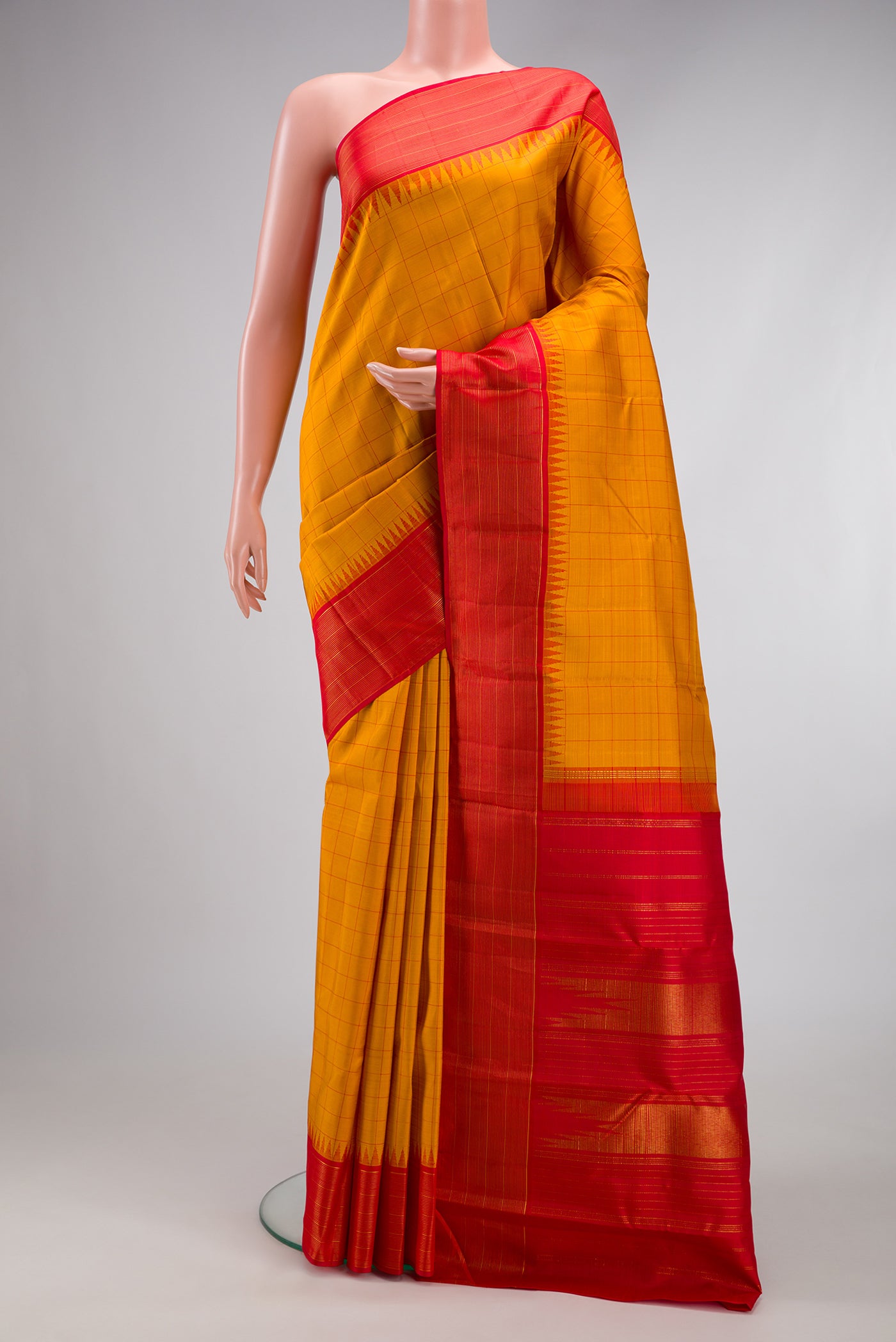 Mustard Kanjivaram Silk Saree with Checked design on the body and Zari Border.  displayed on a mannequin