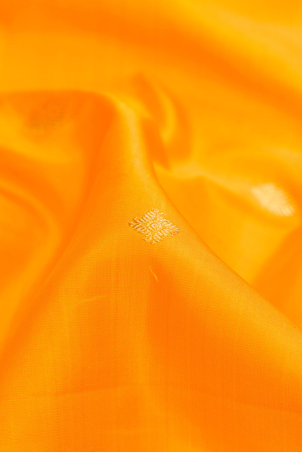 Close up of Pure Silk Pure Zari Yellow Dual Tone Kanjivaram Saree with Zari Butta on the body and Zari Border.  displaying folds