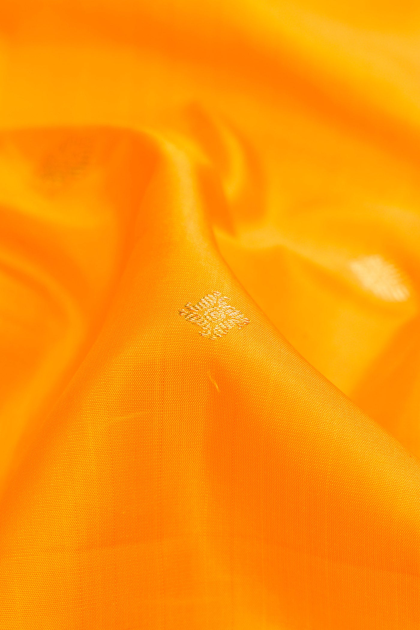 Close up of Pure Silk Pure Zari Yellow Dual Tone Kanjivaram Saree with Zari Butta on the body and Zari Border.  displaying folds