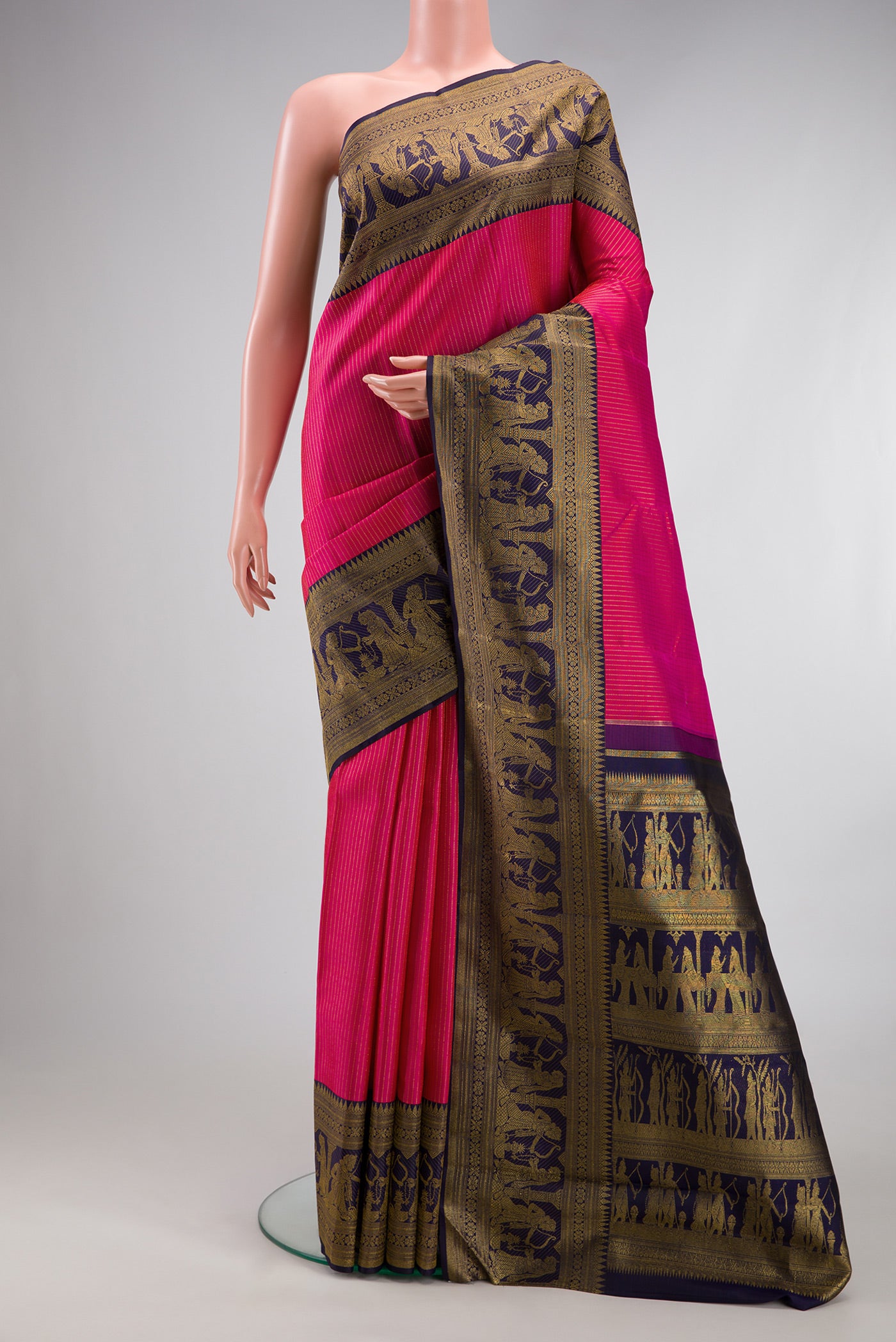 Rani Pink Kanchipuram Silk Saree with Stripes on the body and Fancy Border.  displayed on a mannequin