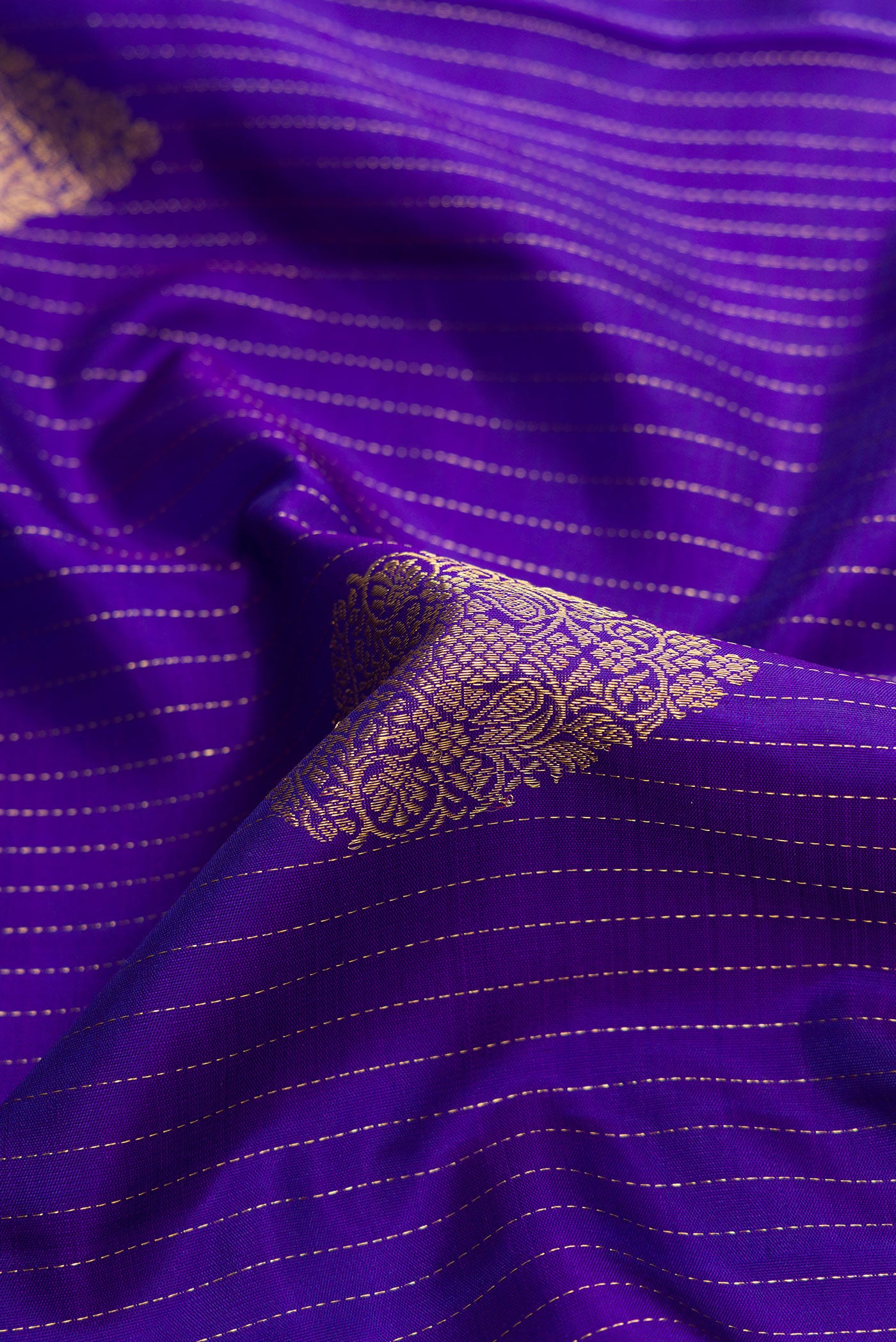 Close up of Royal Blue Dual Tone Kanjivaram Silk Saree with Zari Butta on the body and Zari Border.  displaying folds