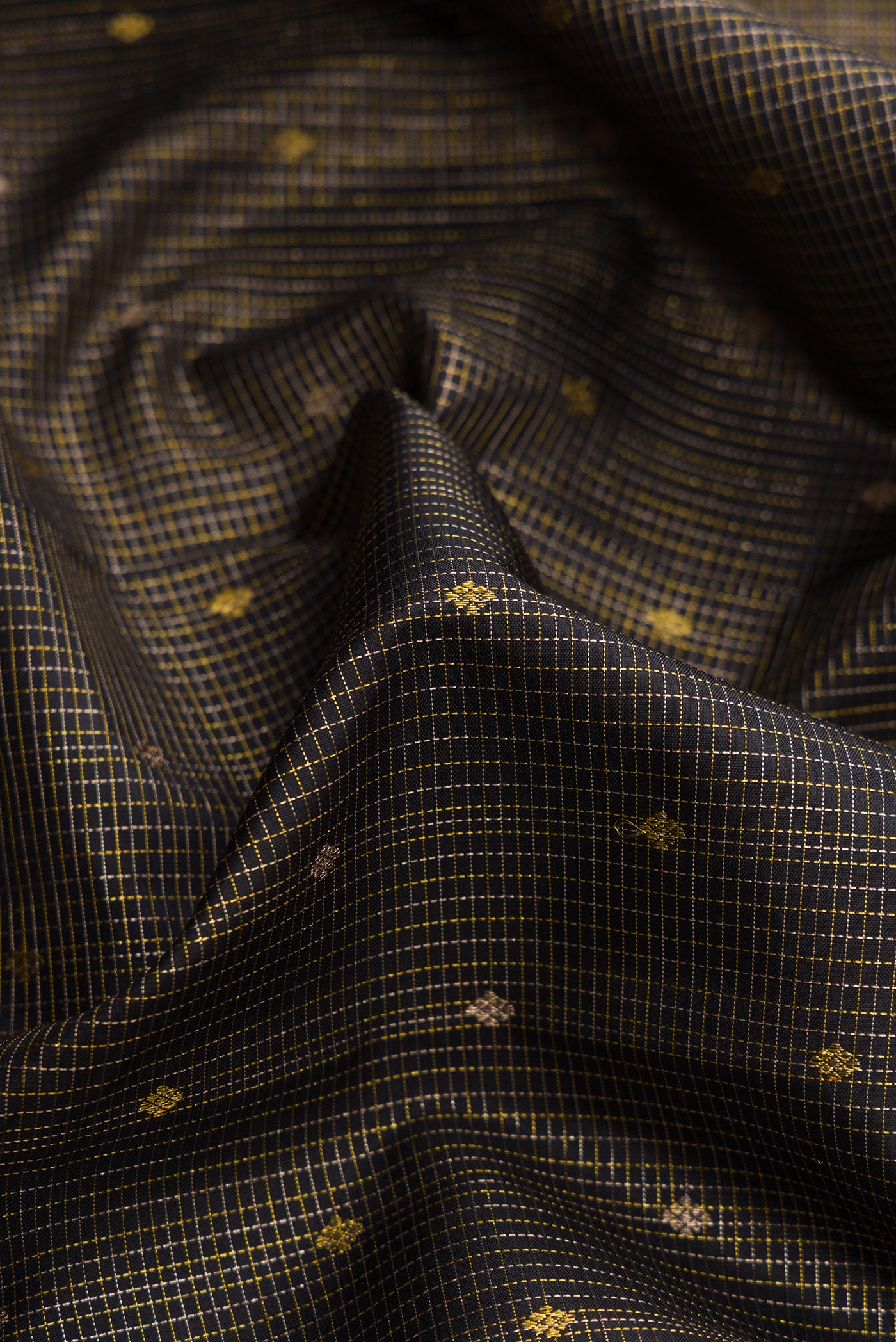 Close up of Pure Silk Pure Zari Black Dual Tone Kanjivaram Saree with Zari Butta on the body and Zari Border.  displaying folds
