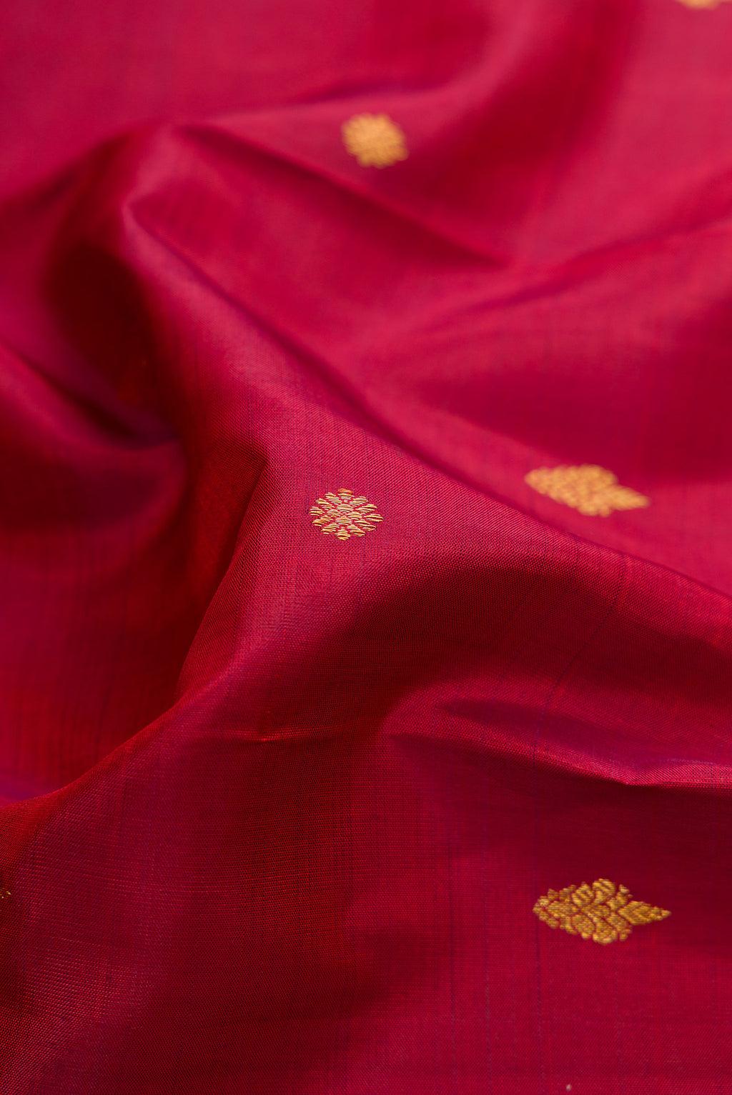 Close up of Pure Silk Pure Zari Maroon Dual Tone Kanjivaram Saree with Zari Butta on the body and Fancy Border.  displaying folds