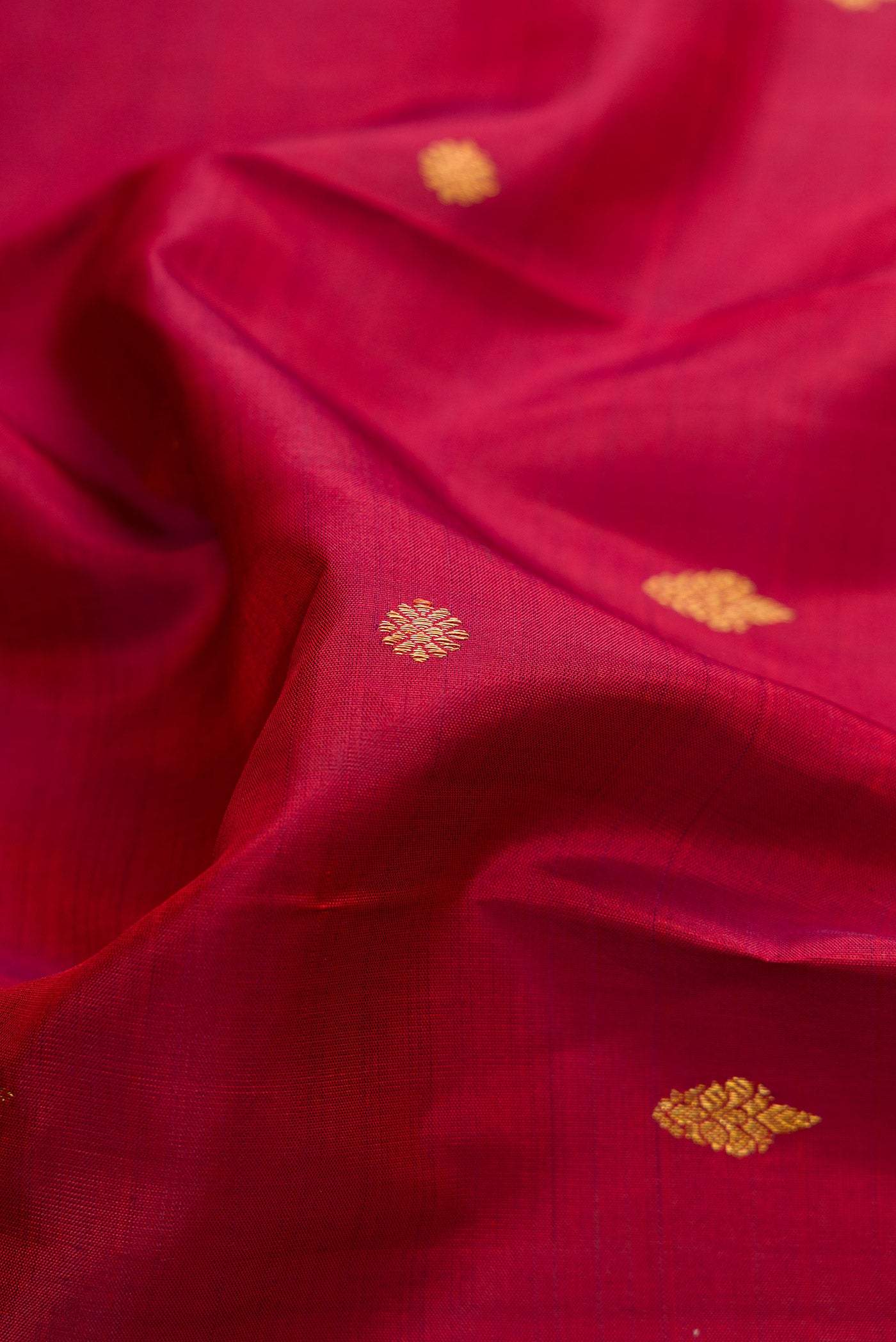 Close up of Pure Silk Pure Zari Maroon Dual Tone Kanjivaram Saree with Zari Butta on the body and Fancy Border.  displaying folds