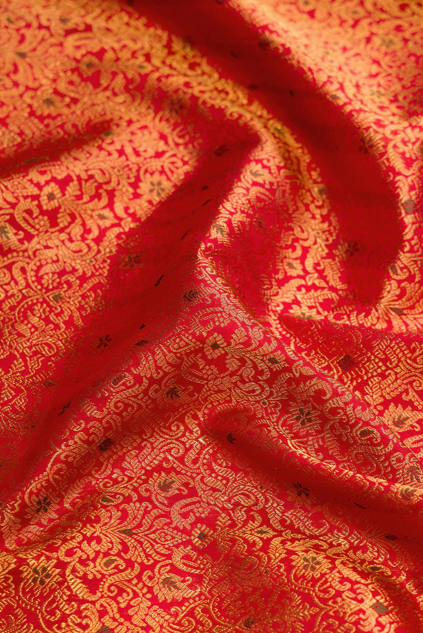 Close up of Red Dual Tone Kanchipuram Silk Saree with Zari Brocade on the body and Zari Border.  displaying folds