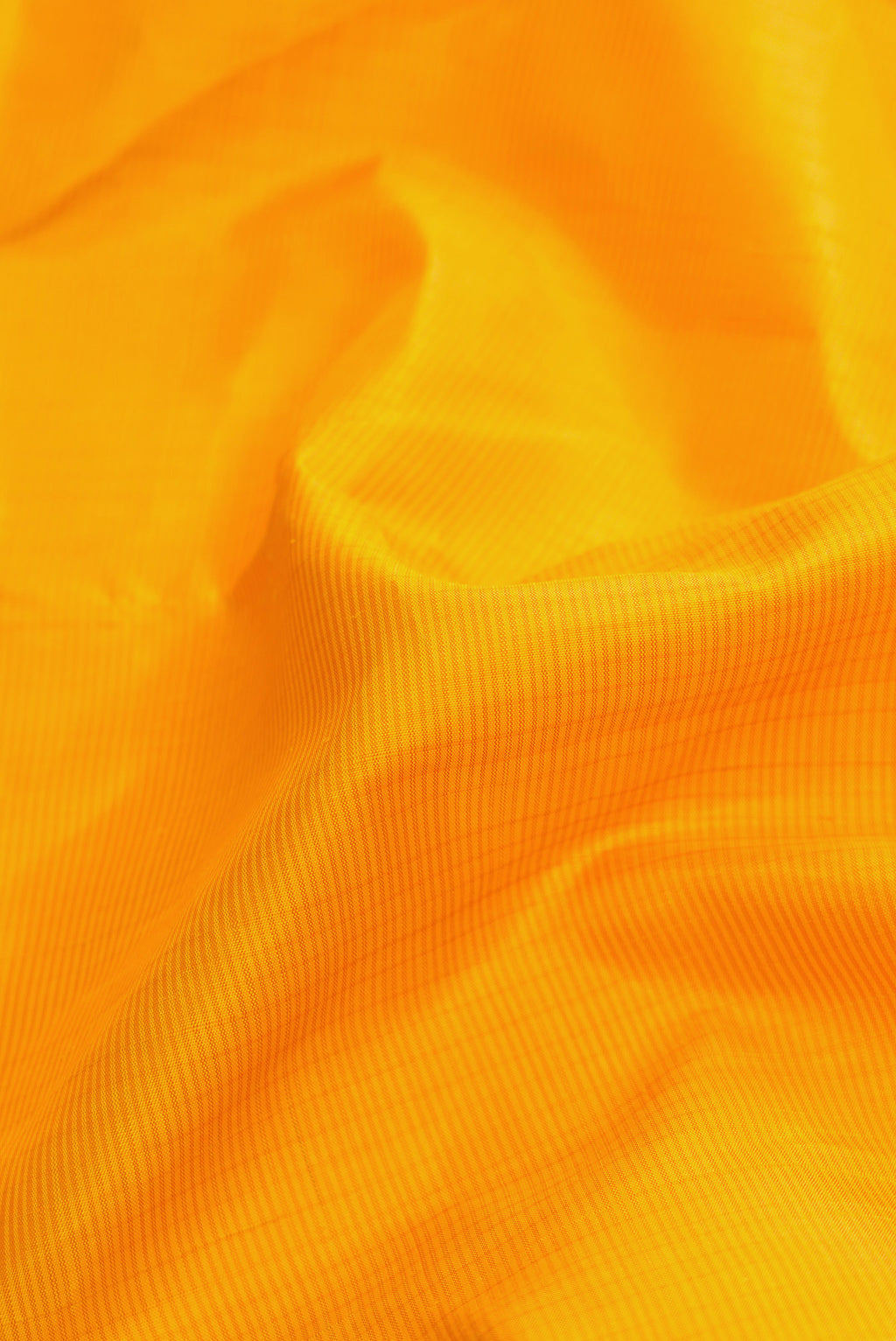 Close up of Mustard Dual Tone Kanjivaram Silk Saree with Stripes on the body and Zari Border.  displaying folds