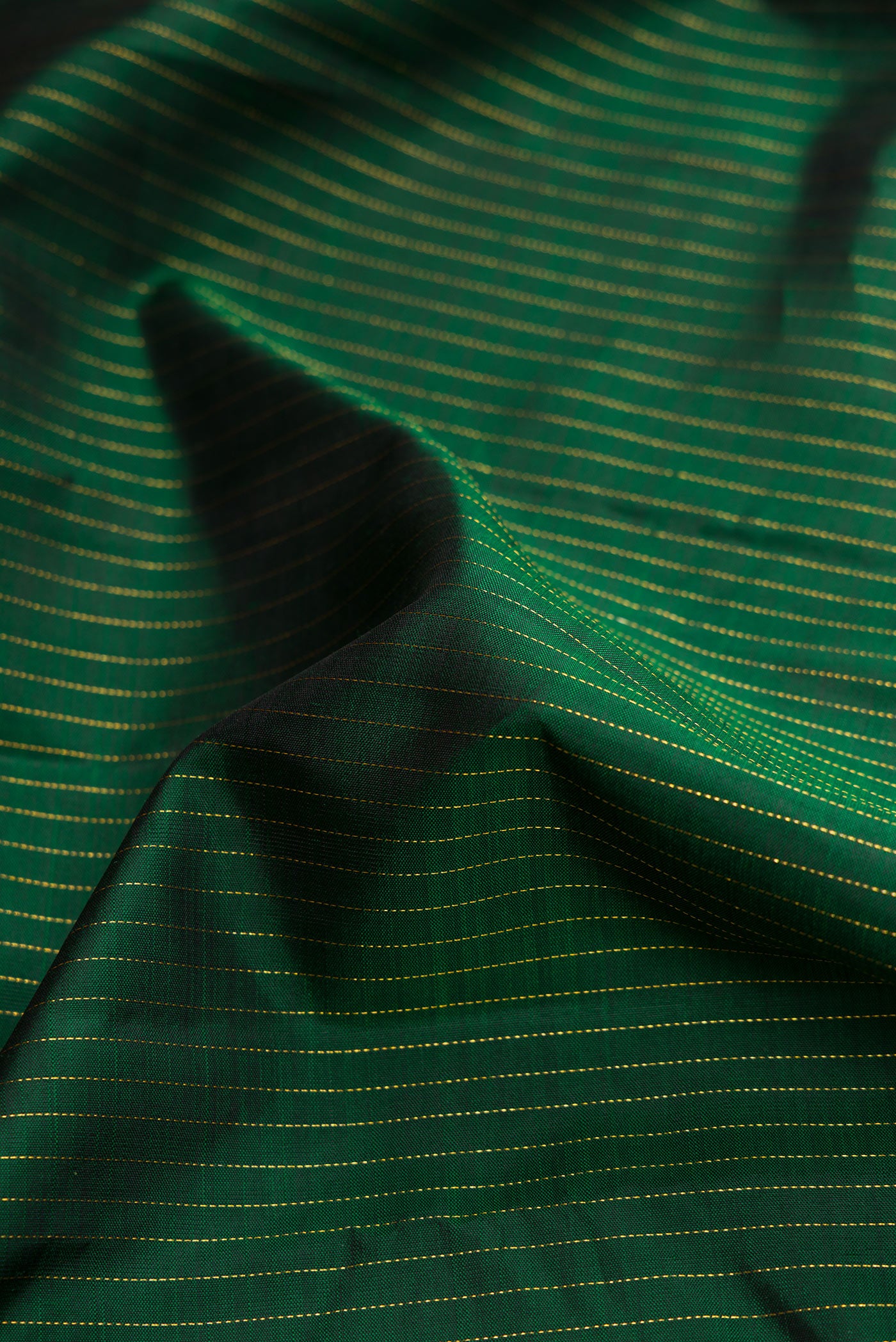 Close up of Green Dual Tone Kanjivaram Silk Saree with Stripes on the body and Without Border.  displaying folds