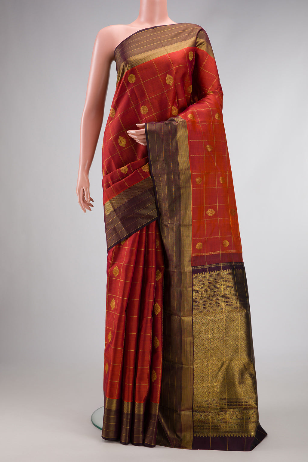 Brick Orange Dual Tone Kanjivaram Silk Saree with Checked design on the body and Zari Border.  displayed on a mannequin