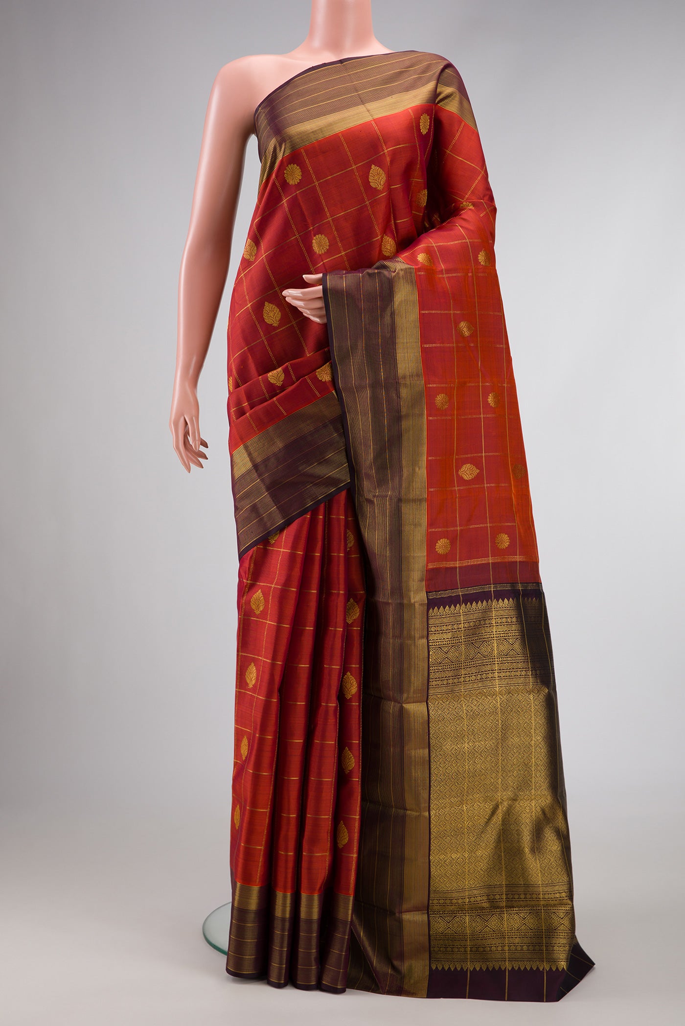 Brick Orange Dual Tone Kanjivaram Silk Saree with Checked design on the body and Zari Border.  displayed on a mannequin