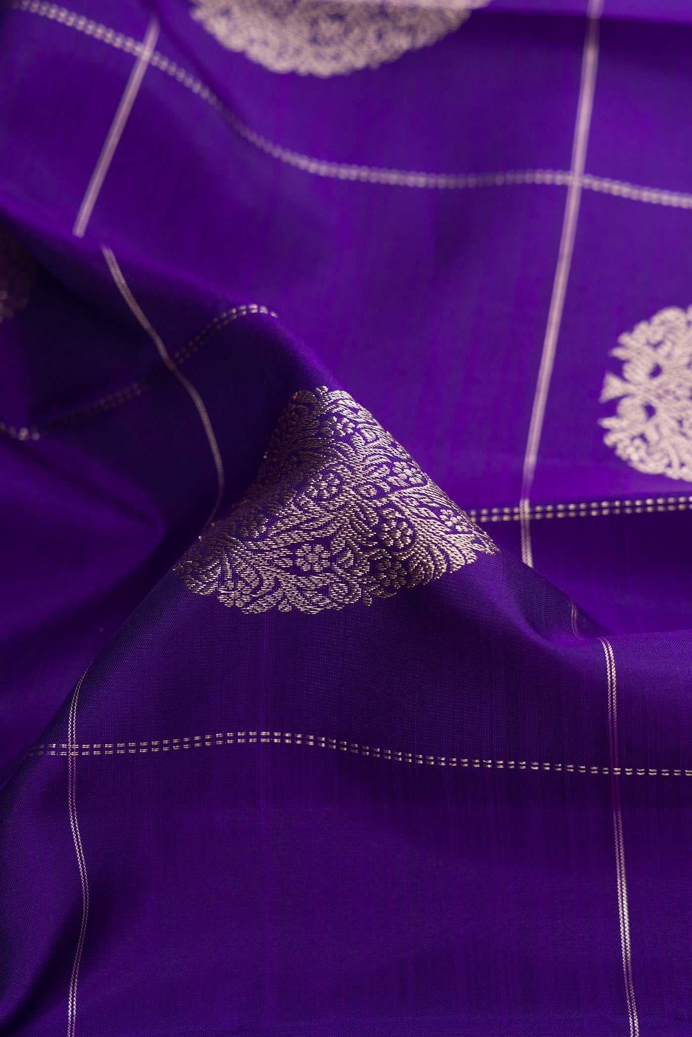 Close up of Royal Blue Dual Tone Kanjivaram Silk Saree with Checked design on the body and Zari Border.  displaying folds