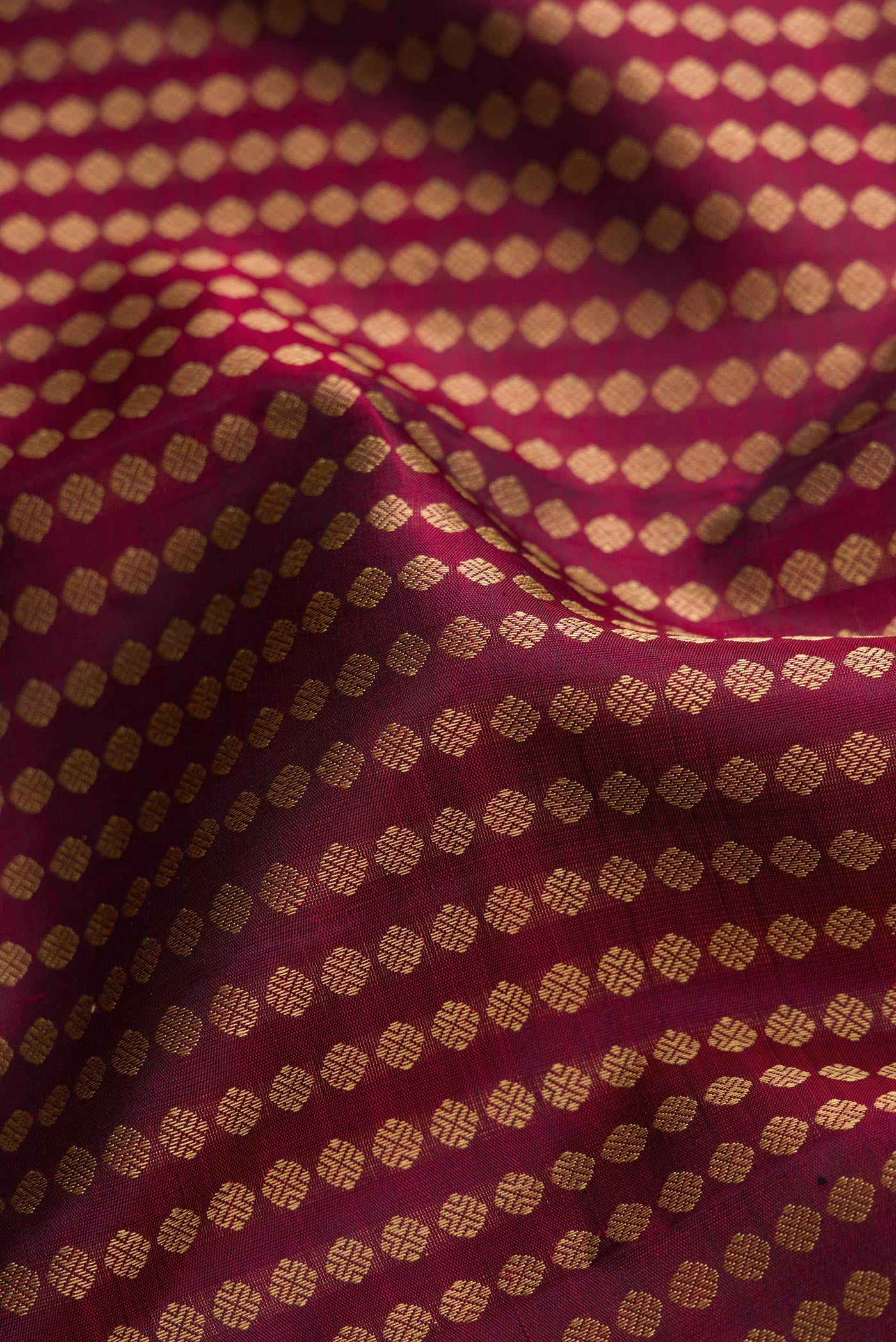 Close up of Burgundy Dual Tone Kanjivaram Silk Saree with Zari Butta on the body and Fancy Border.  displaying folds