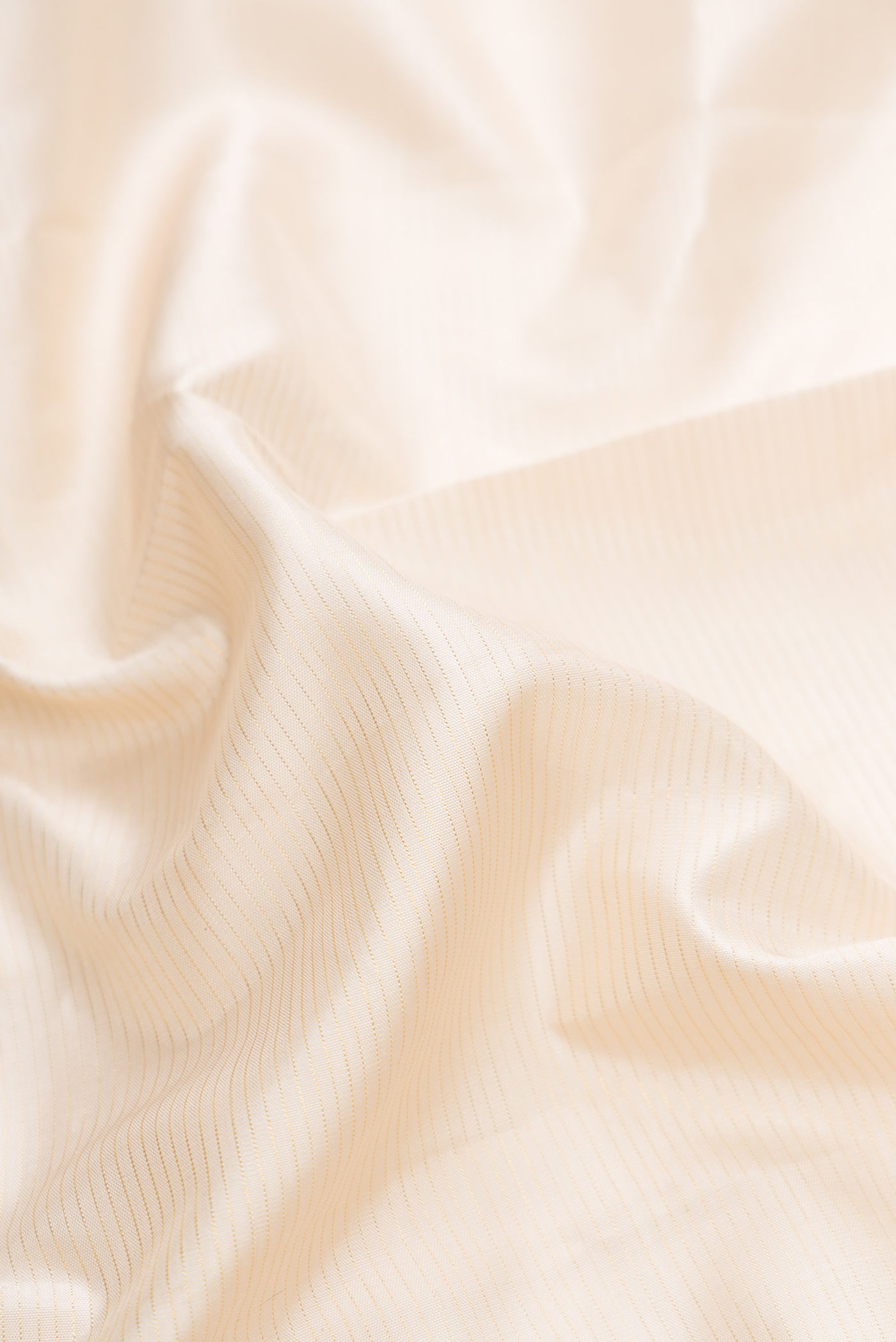 Close up of Pure Silk Pure Zari Off White Dual Tone Kanchipuram Saree with Stripes on the body and Zari Border.  displaying folds
