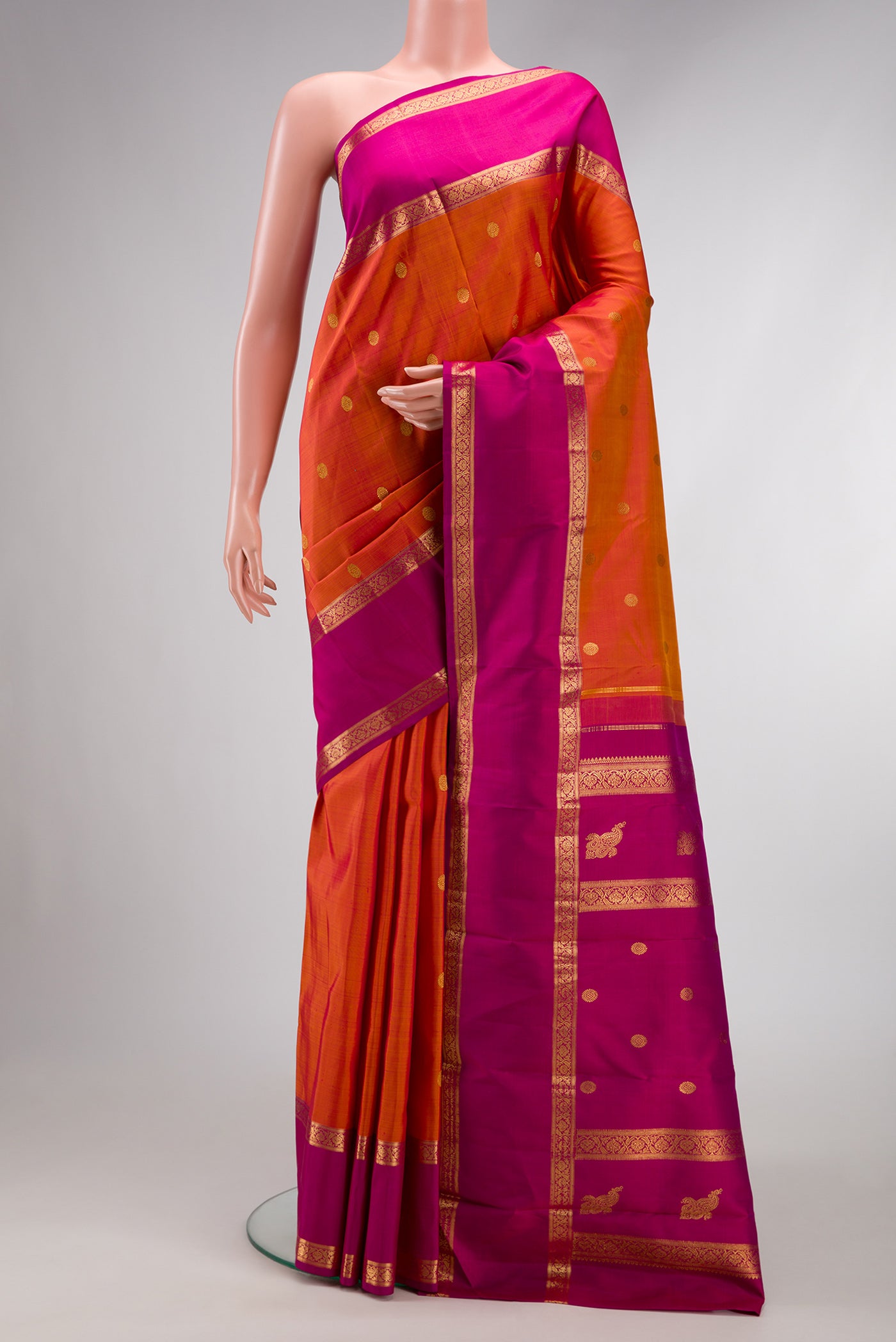 Pure Silk Pure Zari Brick Orange Dual Tone Kanjivaram Saree with Zari Butta on the body and Zari Border.  displayed on a mannequin