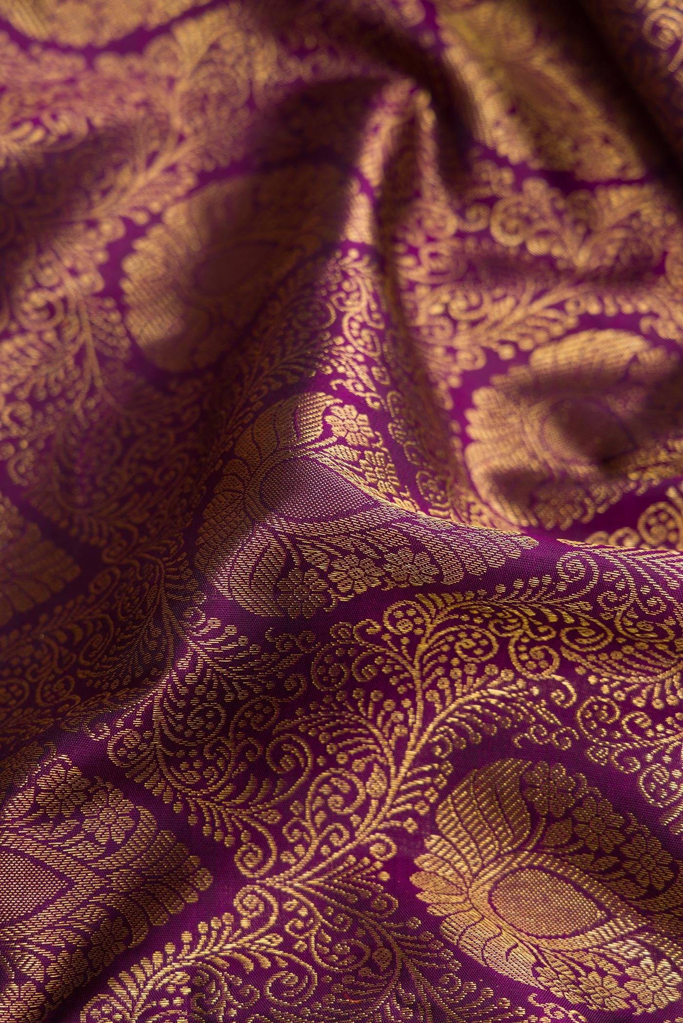 Close up of Pure Silk Pure Zari Purple Dual Tone Kanjivaram Saree with Zari Brocade on the body and Zari Border.  displaying folds