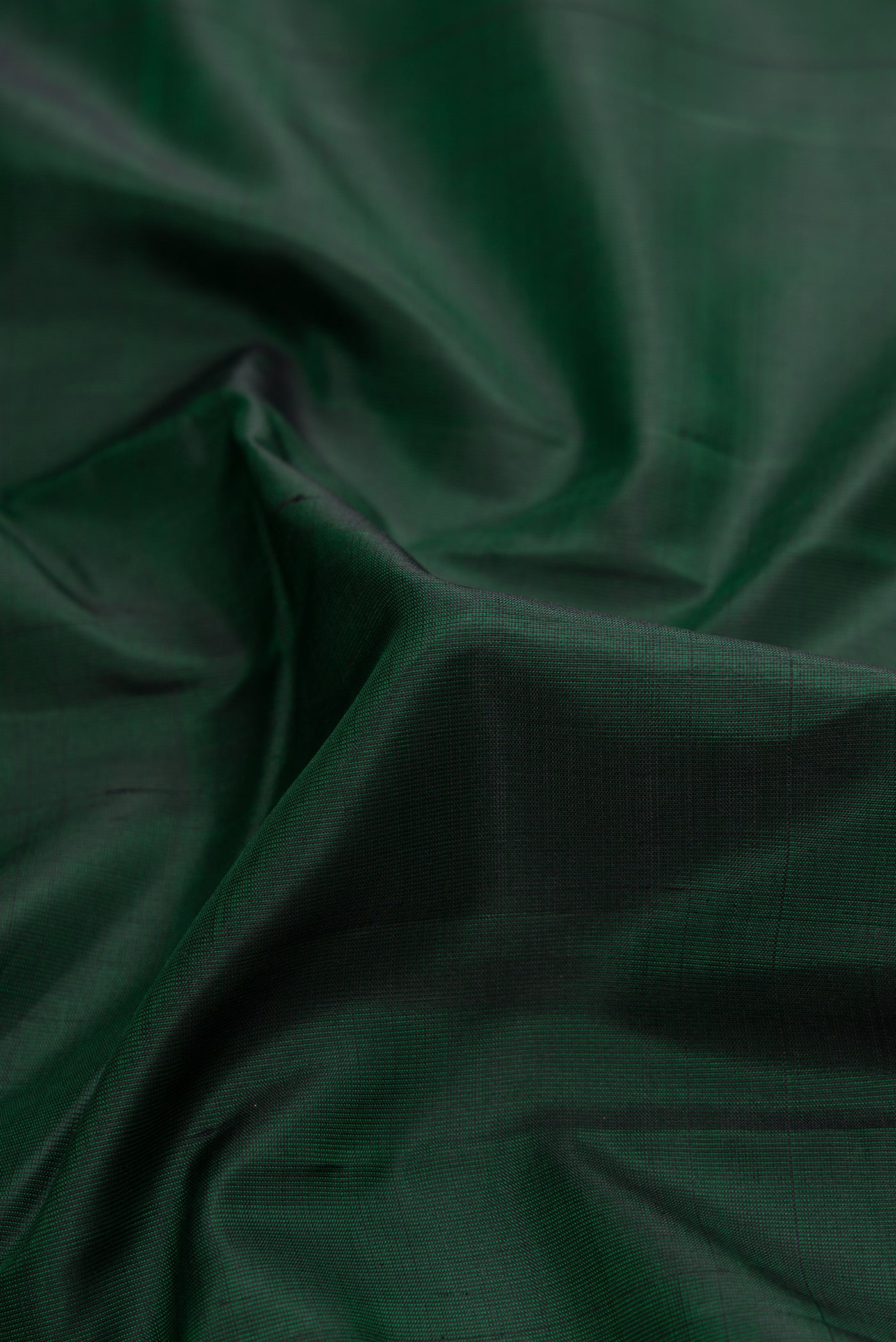 Close up of Bottle Green Dual Tone Kanjivaram Silk Saree with Plain Body and Zari Border.  displaying folds